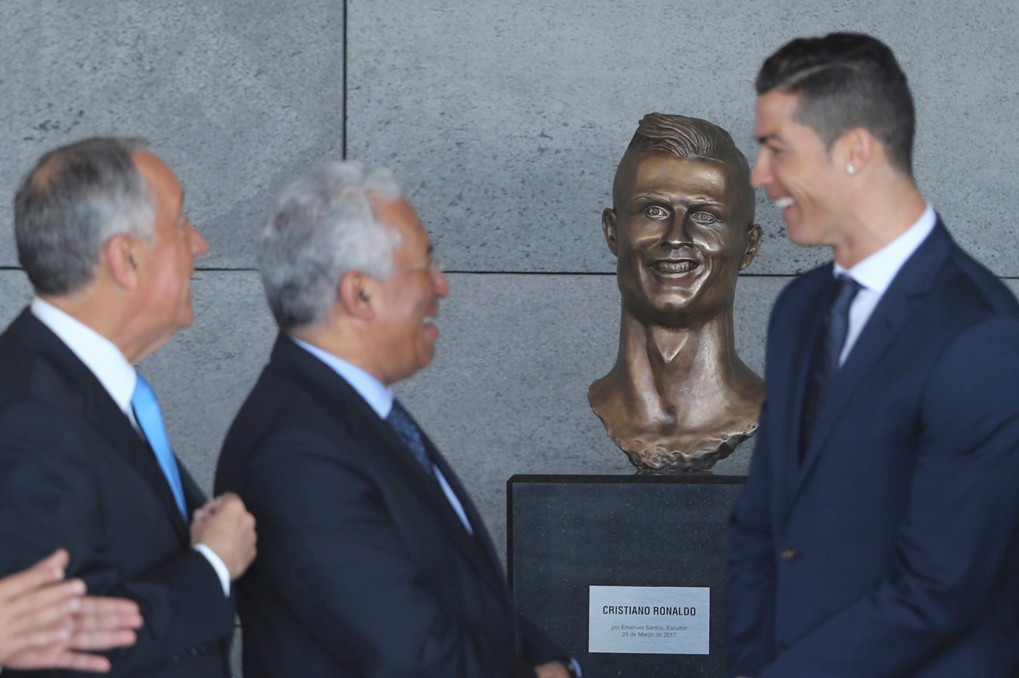 Portuguese president Marcelo Rebelo de Sousa, left, Portuguese Prime Minister Antonio Costa, 2nd left and Real Madrid's Cristiano Ronaldo stand next to a bust of the player at the Madeira international airport outside Funchal, the capital of Madeira island, Portugal, Wednesday March 29, 2017. Madeira International Airport has been renamed after local soccer star Cristiano Ronaldo on Wednesday during a ceremony, with family, at the airport outside his Funchal hometown. (AP Photo/Armando Franca) APTOPIX Portugal Cristiano Ronaldo Airport