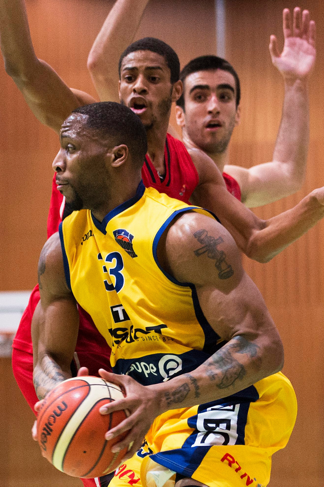 Le joueur neuchatelois, Juwann James, lutte pour le ballon avec les joueurs lausannois, Yohan Frederic, milieu et Milos Bozovic, droite, lors de la rencontre du championnat suisse LNA de basketball, Swiss Basketball League, entre lÄôUnion Neuchatel Basket et le BBC Lausanne, ce vendredi 10 fevrier a la salle de la Riveraine a Neuchatel. (KEYSTONE/Thomas Delley)
 SCHWEIZ BASKETBALL NEUCHATEL LAUSANNE