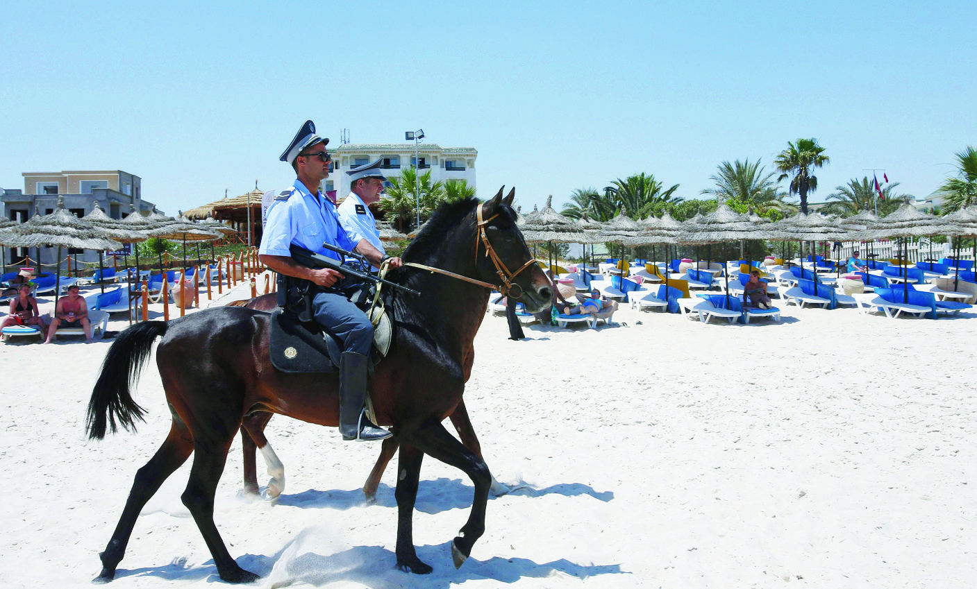 FILE - In this June 28 2015 file photo, mounted police officers patrol on the beach of  Sousse, Tunisia. The blood on the sand has washed away, but the damage wreaked on Tunisia by a few terrifying minutes of gunfire at a beach resort will be deep and lasting. The tourist economy is likely to be gutted: Up to 2 million hotel nights per year are expected to be lost, hastened by warnings from Britain and other European governments last week that their citizens are no longer safe on . (AP Photo/Abdeljalil Bounhar, File) Tunisia Tourism