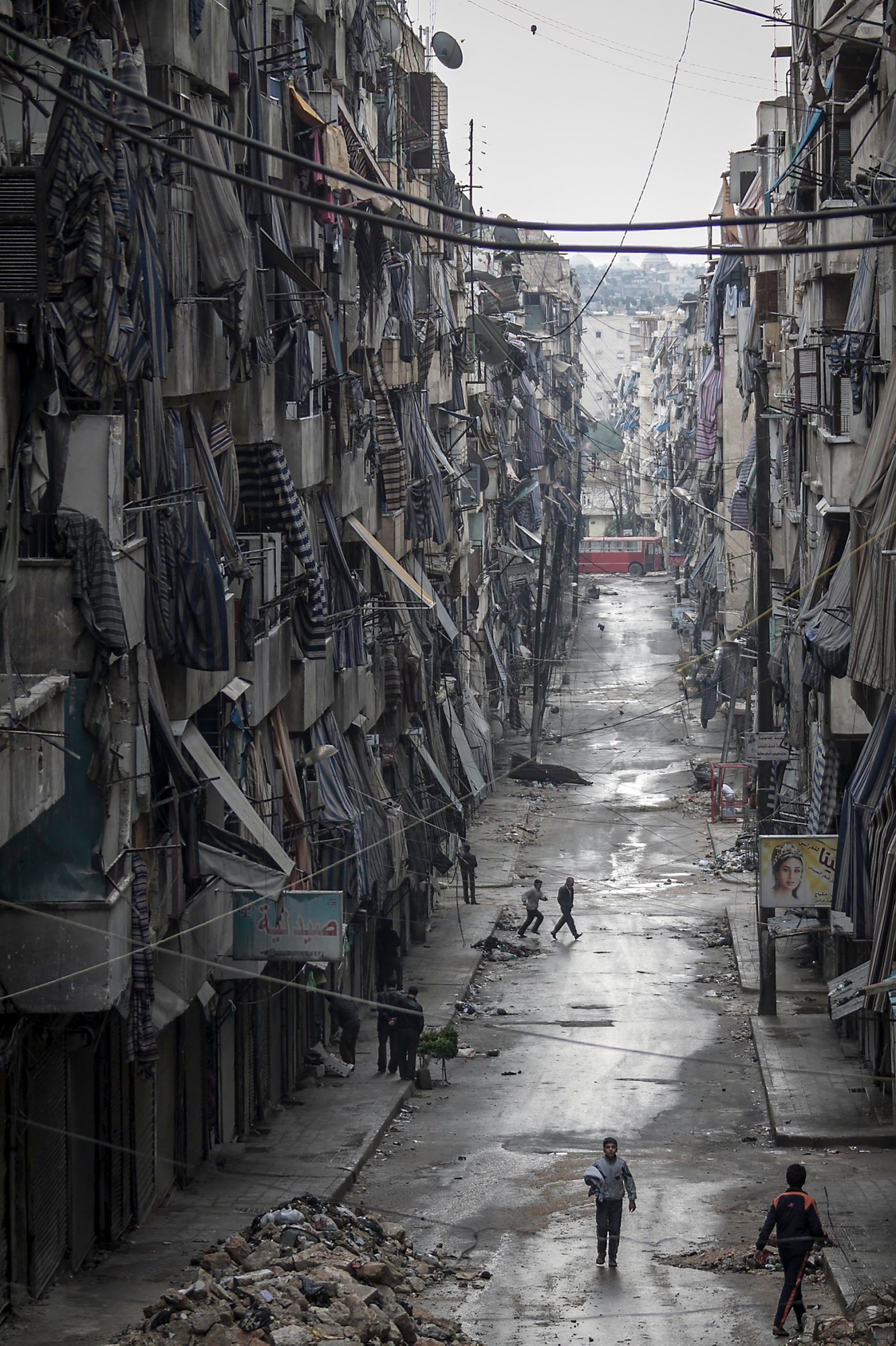 Syrians walk past damaged homes during heavy fighting between Free Syrian Army fighters and government forces in Aleppo, Syria, Tuesday, Dec. 4, 2012. (AP Photo/Narciso Contreras) Mideast Syria