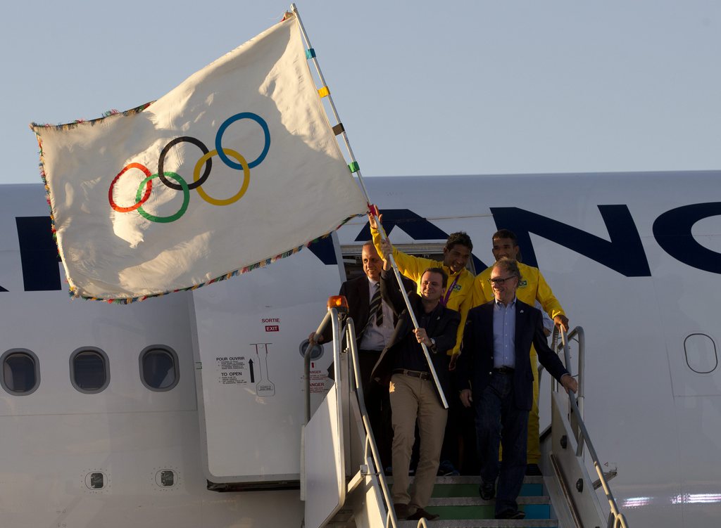 Le maire de la ville de Rio de Janeiro, Eduardo Paes (devant à gauche), est descendu d'avion en portant la flamme, accompagné de Carlos Arthur Nuzman, le président du Comité d'organisation des JO 2016, et du gouverneur de l'Etat de Rio Sergio Cabral.