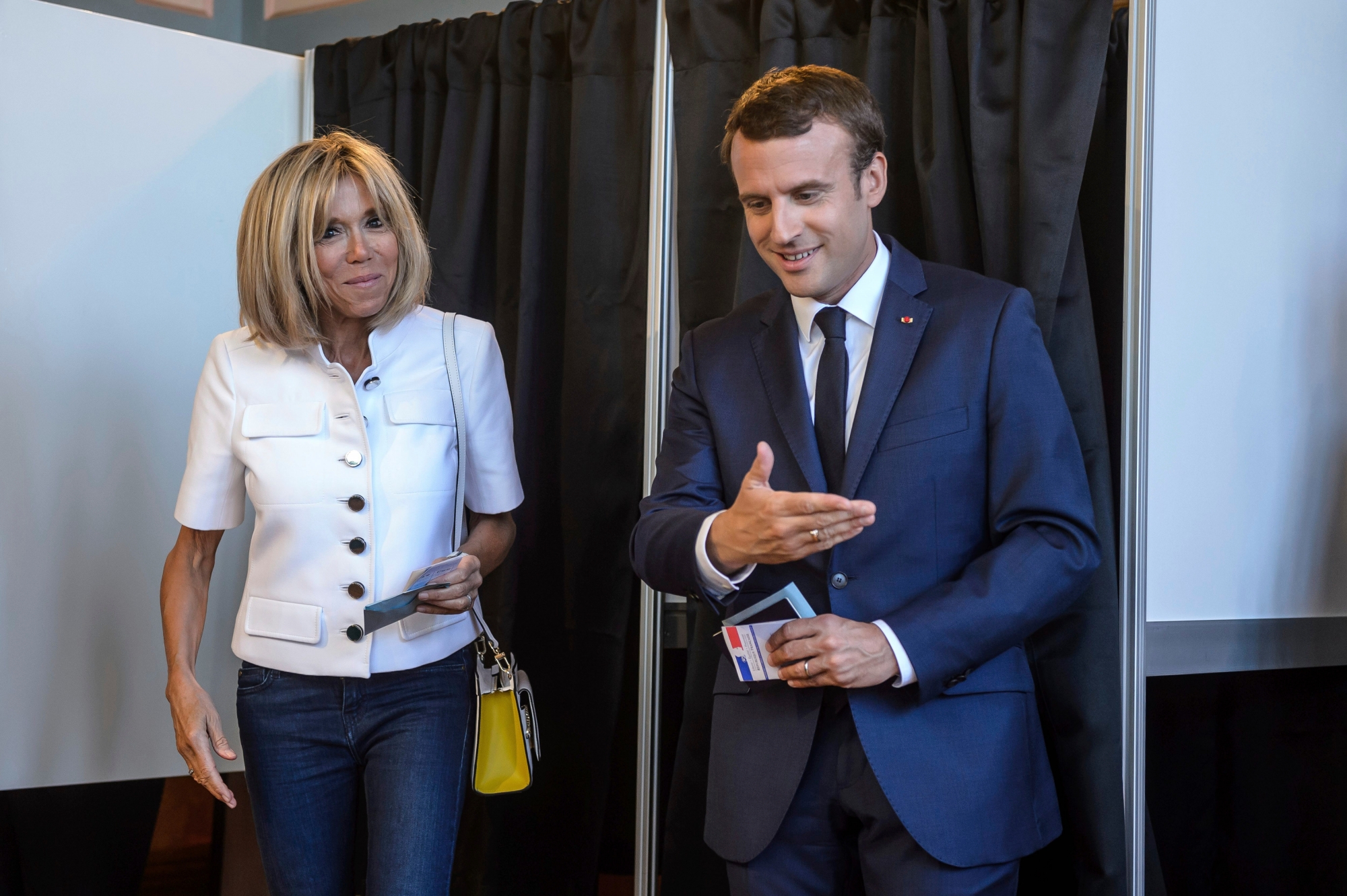 French President Emmanuel Macron and his wife Brigitte Macron leave a polling booth as they vote in the first round of the two-stage legislative elections, in Le Touquet, northern France, Sunday, June 11, 2017. French voters are choosing legislators in the first round of parliamentary elections, with President Emmanuel Macron's party "Republic on the Move" hoping to win a strong majority in the National Assembly to push through bold labor and security reforms. (Christophe Petit-Tesson/Pool Photo via AP) France Elections