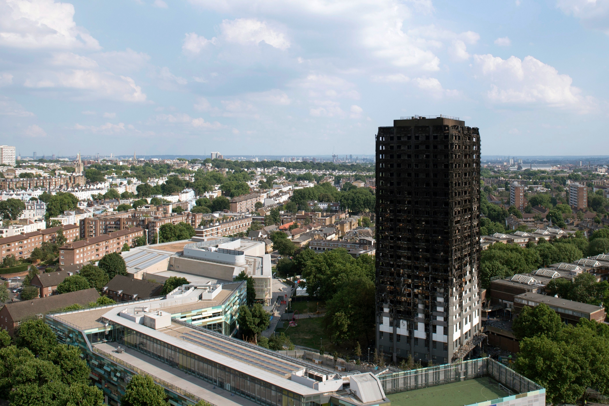 epa06035746 A general view of the remains of Grenfell Tower, a 24-storey apartment block in North Kensington, London, Britain, 18 June 2017. Search and Rescue efforts are continuing to sift through the burnt out remains of the tower. At least 58 people are now missing and presumed dead in the Grenfell Tower disaster, police have said. This latest figure includes the 30 already confirmed to have died in the fire.The cause of the fire is yet not known.  EPA/WILL OLIVER BRITAIN TOWER BLOCK FIRE AFTERMATH