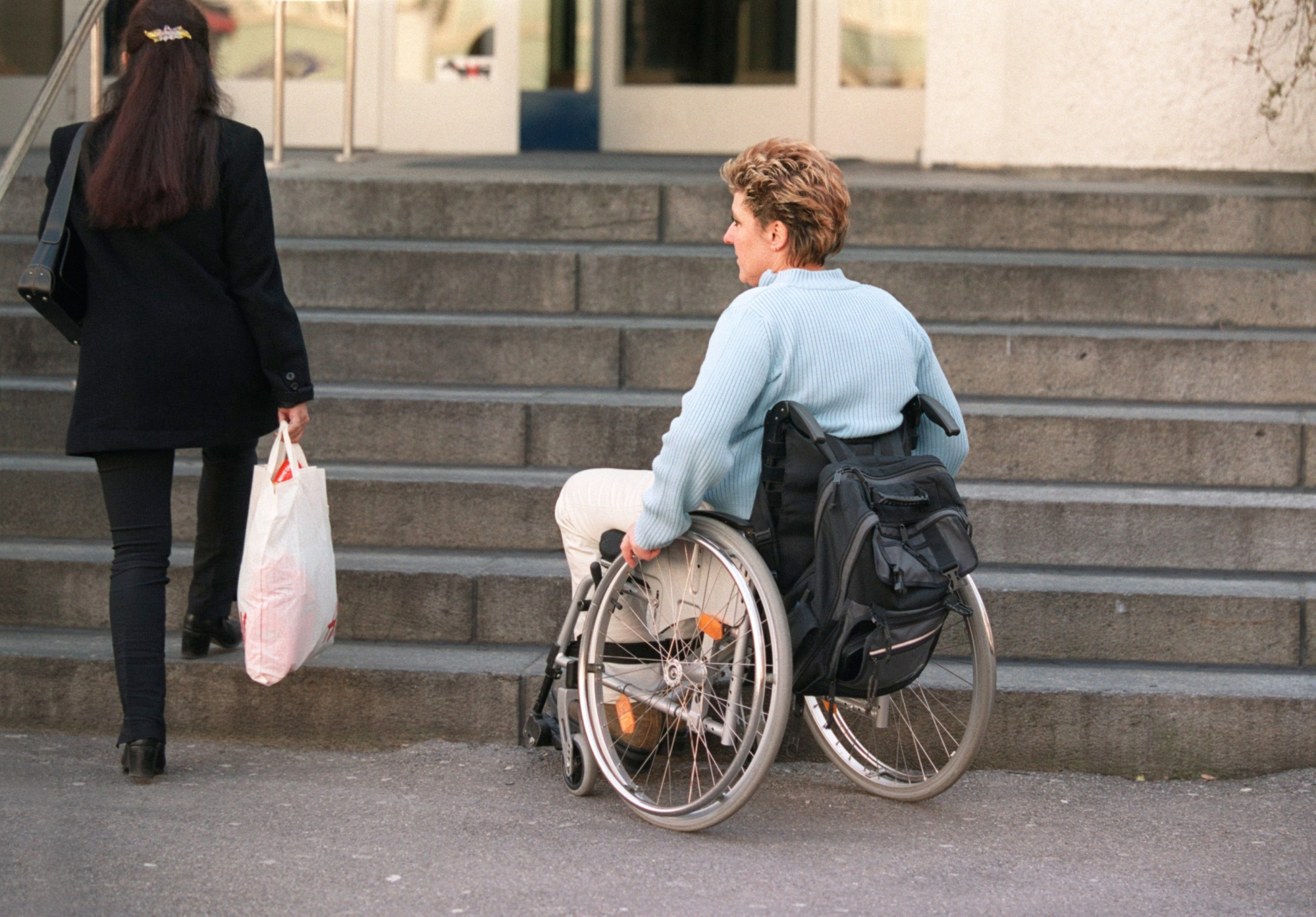 Die gehbehinderte Thea Mauchle (Verfassungsraetin SP) moechte am 20. Maerz 2003 in Zuerich eine Treppe hinauf. Ein schwieriges Unterfangen ohne die Hilfe ihrer Mitmenschen. Mauchle ist seit etwa 10 Jahren durch einen Unfall an den Rollstuhl gefesselt und zeigt auf dieser Aufnahme die Tuecken des Stadtlebens fuer Menschen im Rollstuhl auf. (KEYSTONE/Gaetan Bally) : FILM] === MODEL RELEASED === SCHWEIZ BEHINDERTE ROLLSTUHL TREPPE