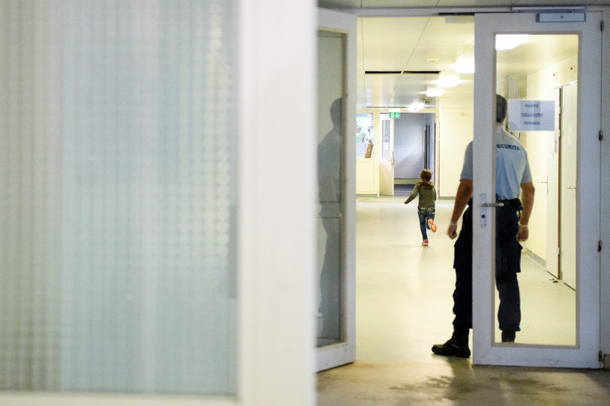 Ein Securitas Mitarbeiter geobachtet ein Kind in einem Gang im Bundesasylzentrum Perreux fotografiert anlaesslich einer Medienbesichtigung am Mittwoch, 11. Mai 2016, in Perreux. (KEYSTONE/Manuel Lopez) SCHWEIZ BUNDESASYLZENTRUM PERREUX