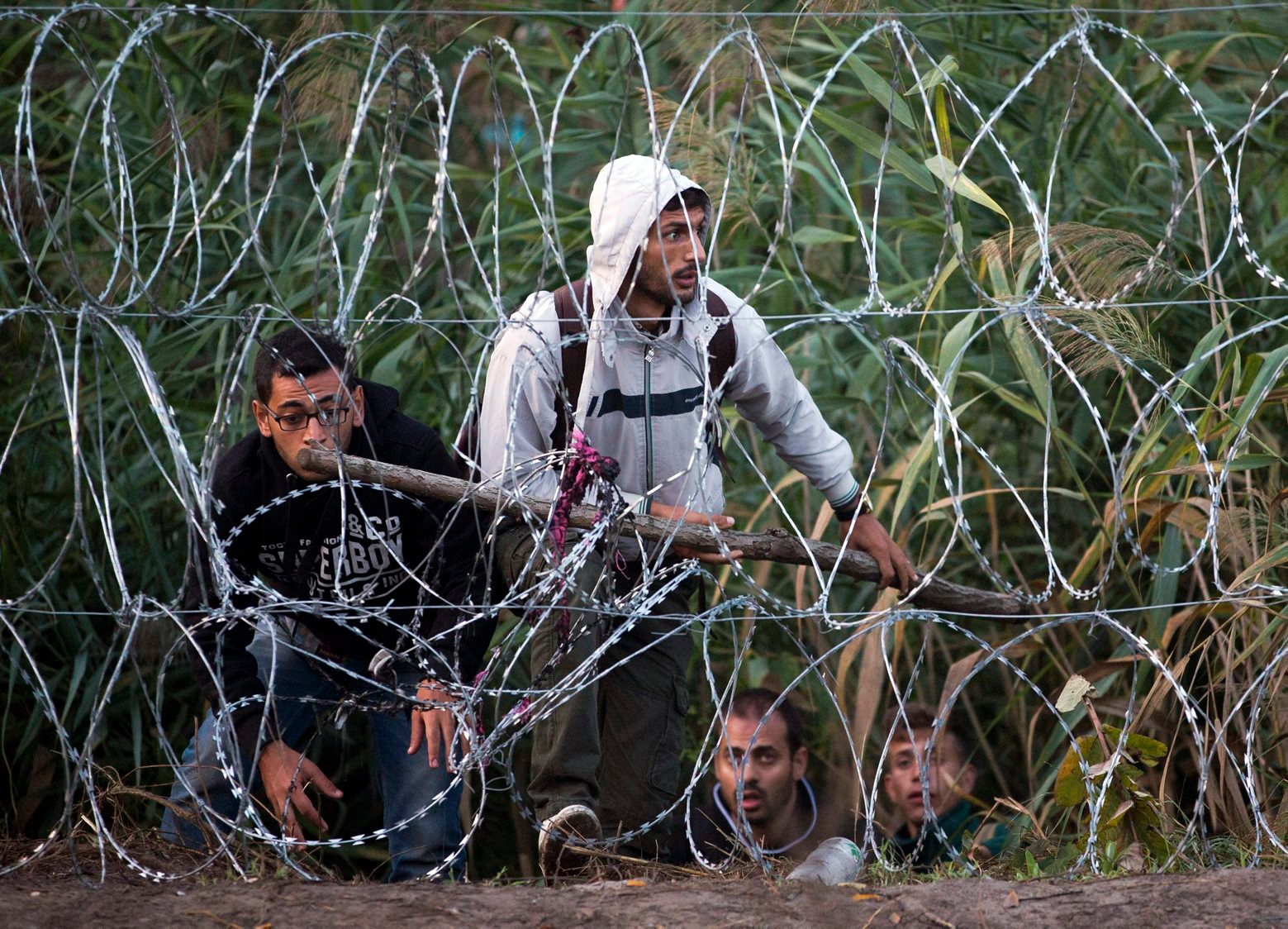 Syrian refugees get ready to enter Hungary from Serbia, on the border near Roszke, Friday, Aug. 28, 2015. Hungary deployed police reinforcements to rein in an unrelenting flow of migrants across its porous border Thursday, but refugee activists said the effort appeared futile in a nation whose migrant camps are overloaded and barely delay their journeys west into the heart of the European Union. (AP Photo/Darko Bandic) Hungary Migrants