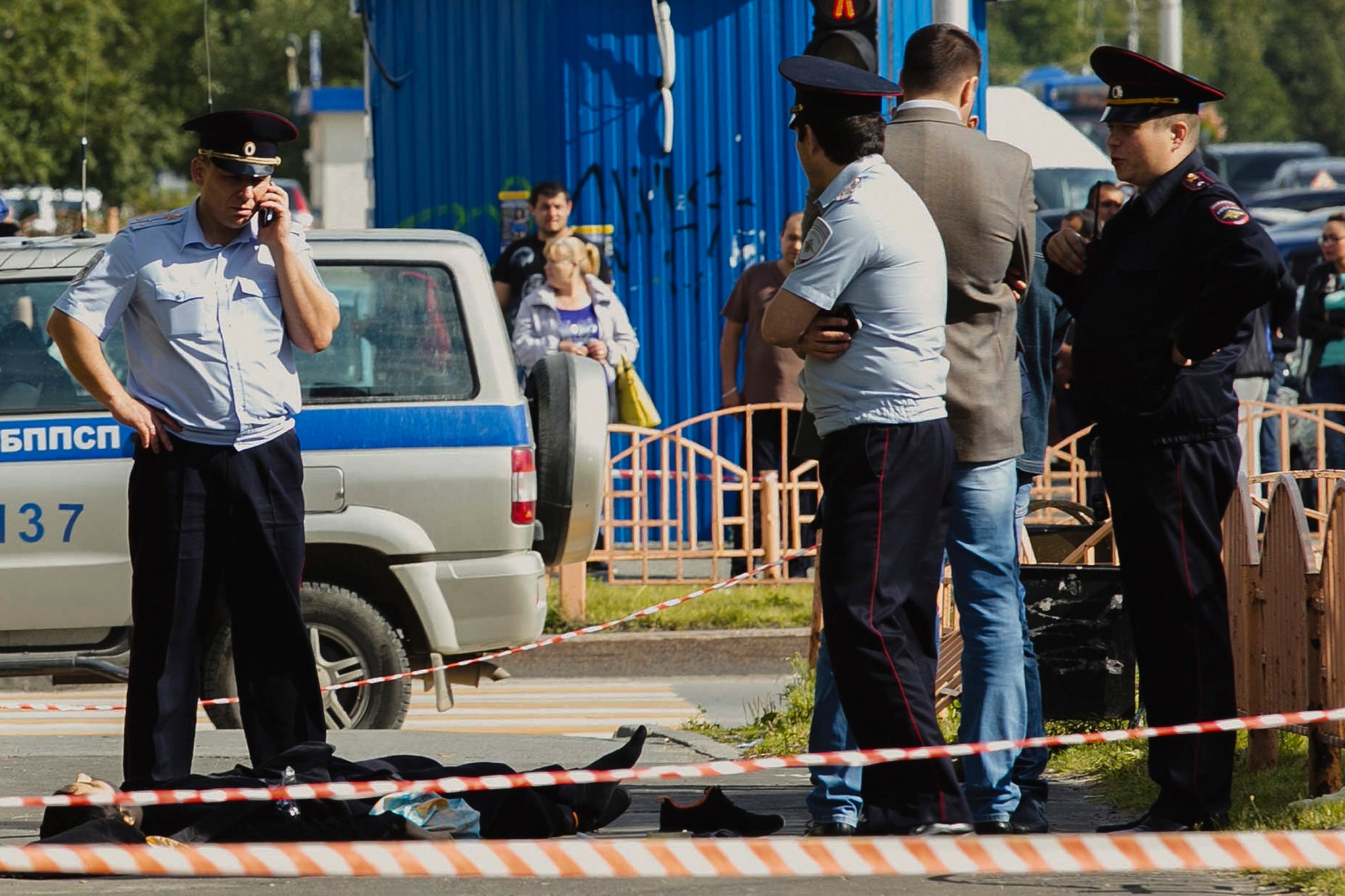 Police officers stand by the body of a man who was killed after an alleged stabbing attack, in the Siberian city of Surgut, Russia, Saturday, Aug. 19, 2017. A knife-wielding man went on a stabbing rampage in a Siberian city on Saturday, wounding seven people before police shot and killed him. (Irina Shvets/Siapress.ru via AP) Russia Attack