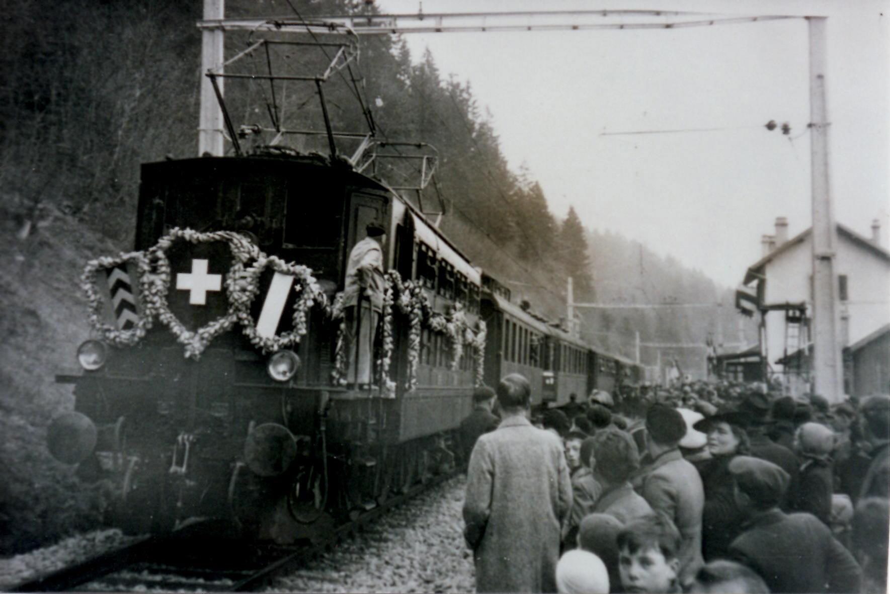 Le 21 novembre 1942, le premier convoi électrique circule entre Neuchâtel et Les Verrières. Ici, la locomotive, l’Ae 3/6 10693, décorée pour l’occasion, s’est arrêtée en gare de Boveresse, où la foule est venue découvrir le train.