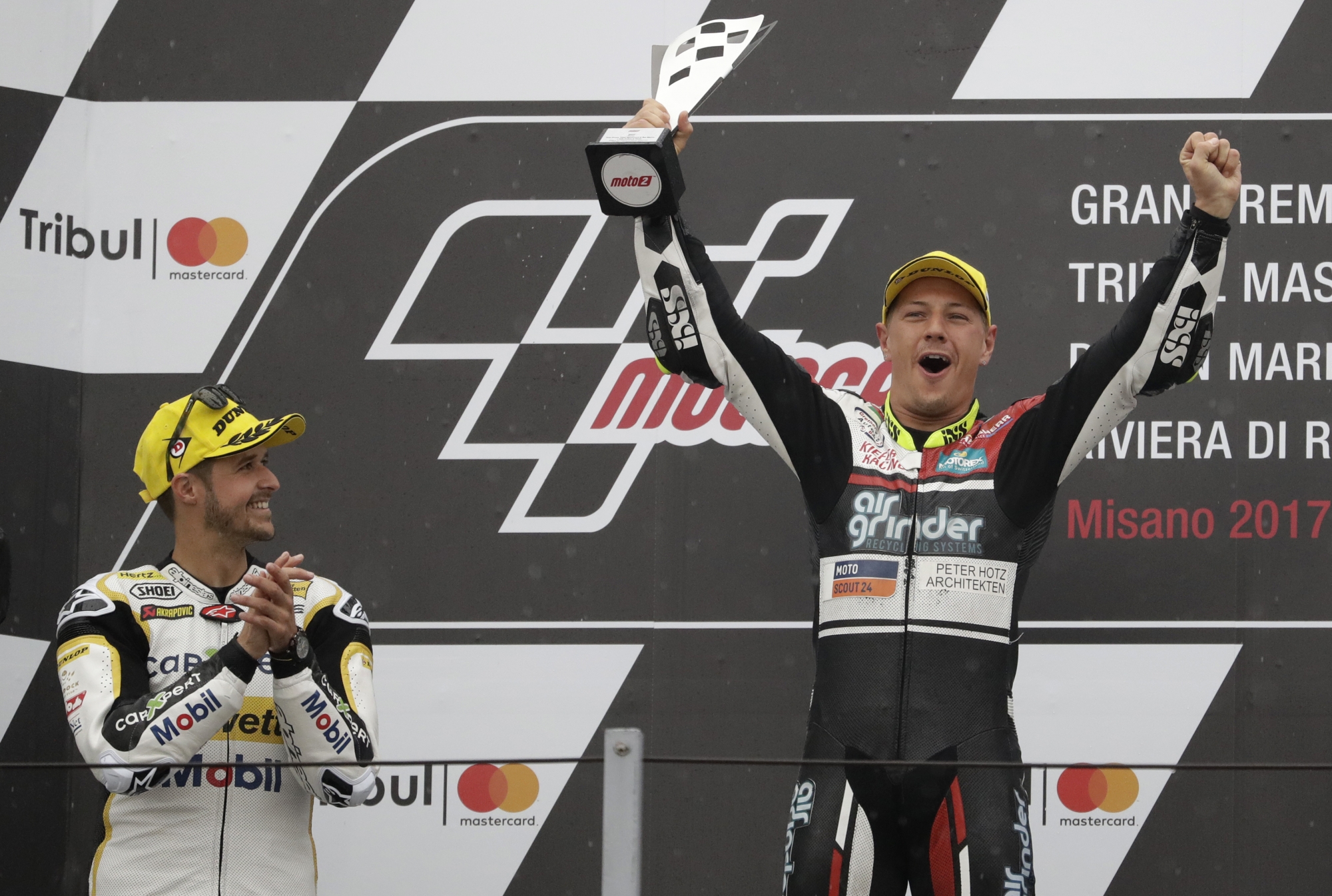 Second placed Moto 2 rider Thomas Luthi of Switzerland, left, applauds as Dominique Aegerter, also of Switzerland, celebrates on the podium after winning the San Marino Motorcycle Grand Prix at the Misano circuit in Misano Adriatico, Italy, Sunday, Sept. 10, 2017. (AP Photo/Antonio Calanni) Italy San Marino Motorcycle Grand Prix