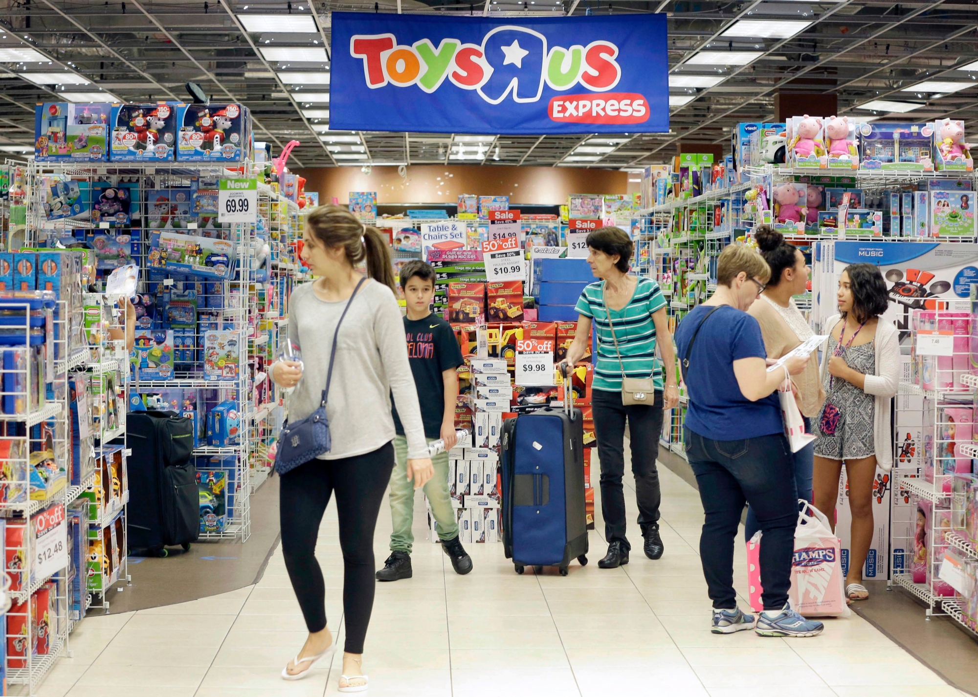 FILE - In this Friday, Nov. 25, 2016, file photo, shoppers shop in a Toys R Us store on Black Friday in Miami. Toys R Us, the pioneering big box toy retailer, announced late Monday, Sept. 18, 2017 it has filed for Chapter 11 bankruptcy protection while continuing with normal business operations. (AP Photo/Alan Diaz, File) Toys R Us