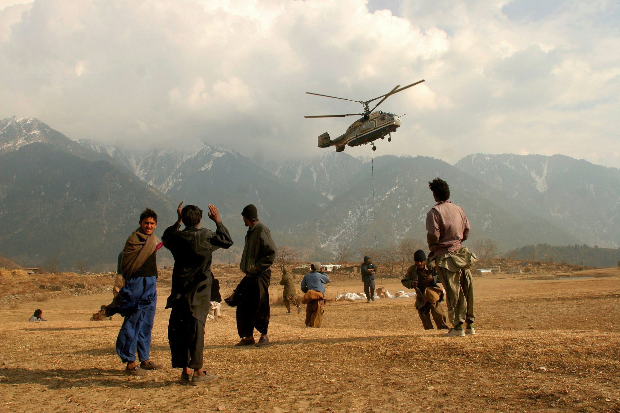 People watch a helicopter from the World Food Program arriving to the village of Paca Biakh in Allai Valley, 70km northwest of Muzaffarabad, Pakistan, Wednesday, Dec. 28, 2005. WFP is delivering food aid to remote villages in high altitude areas isolated by October's earthquake and providing medical care with a local NGO. (KEYSTONE/AP/Tomas Munita) PAKISTAN SOUTH ASIA EARTHQUAKE