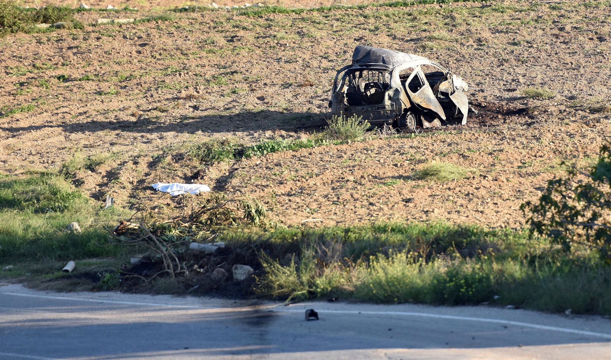 The wreckage of the car of investigative journalist Daphne Caruana Galizia lies next to a road in the town of Mosta, Malta, Monday, Oct. 16, 2017. Malta's prime minister says a car bomb has killed an investigative journalist on the island nation. Prime Minister Joseph Muscat said the bomb that killed reporter Daphne Caruana Galizia exploded Monday afternoon as she left her home in a town outside Malta's capital, Valetta. (AP Photo/Rene Rossignaud) Malta Journalist Killed