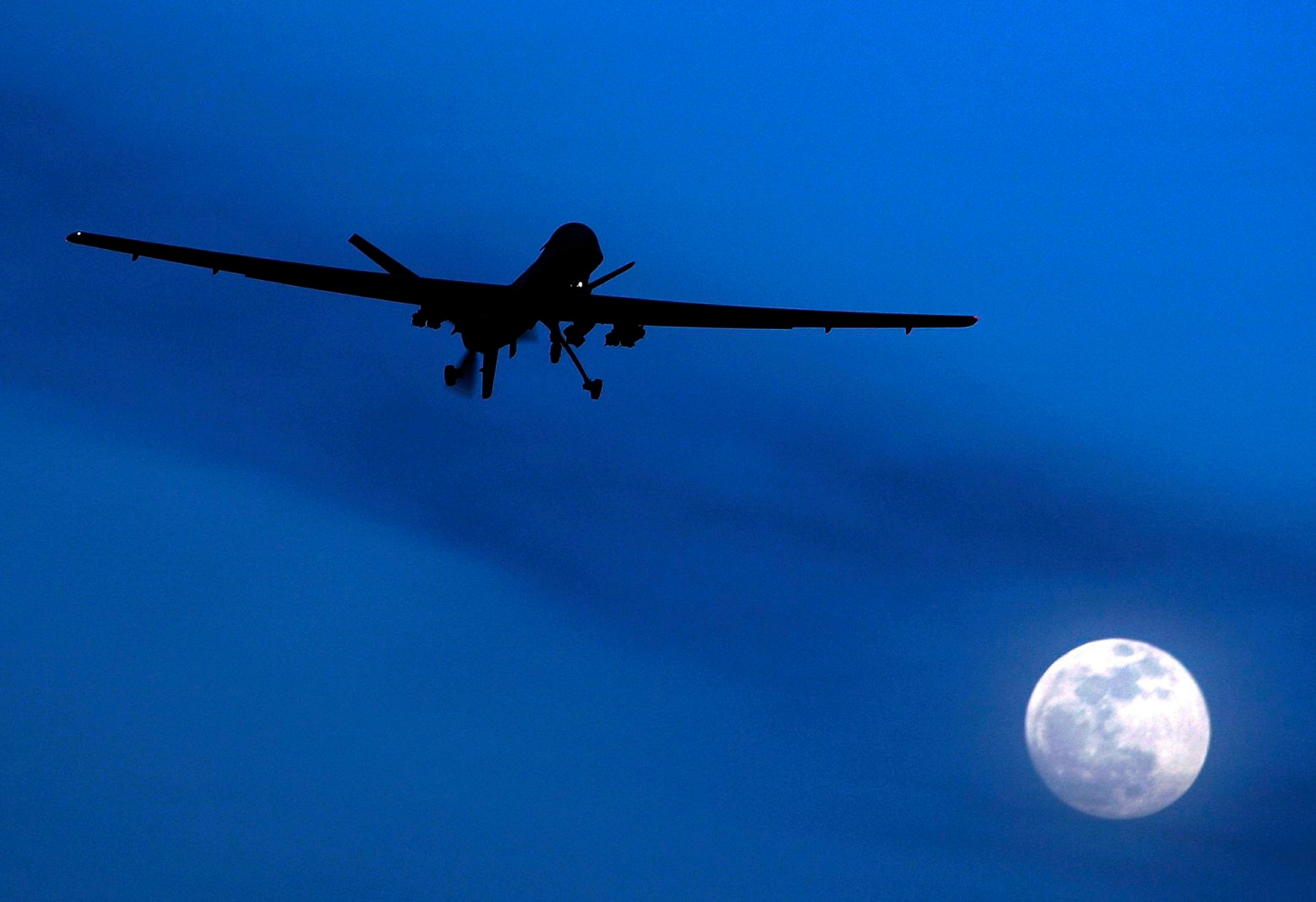 FILE - In this Jan. 31, 2010 file photo, an unmanned U.S. Predator drone flies over Kandahar Air Field, southern Afghanistan, on a moon-lit night. Amnesty International calls on the U.S. to investigate reported civilian casualties from CIA drone strikes in Pakistan and compensate victims in a report providing new details about innocent citizens allegedly killed in the attacks. (AP Photo/Kirsty Wigglesworth, File) Pakistan Amnesty Drones