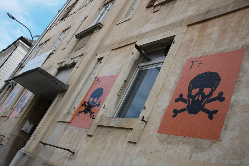 Pose d'affiches "Toxique +" sur la façade est de l'immeuble chaux-de-fonnier pollué de Doubs 51 en 2017.