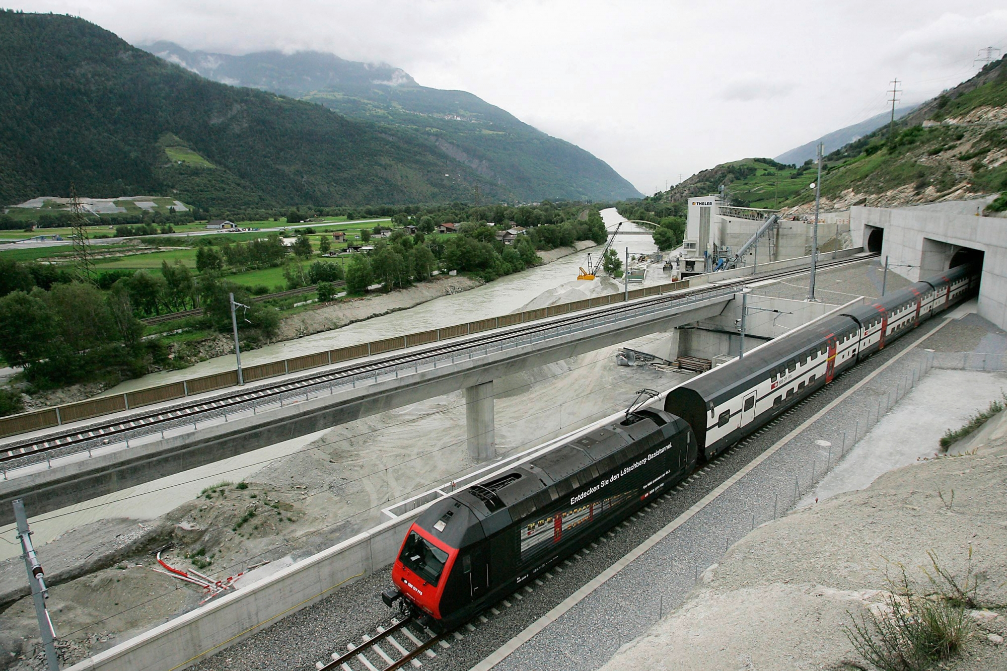 The first train passing the tunnel arrives on the south side, during the inauguration day of the Loetschberg railway Tunnel in Raron, Switzerland, Friday, June 15, 2007. The 34,6 kilometres long transalpine base tunnel between Frutigen in the canton Berne and Raron in the Canton Valais is the longest railway tunnel in Switzerland and the third longest in the World. (KEYSTONE/Olivier Maire) SWITZERLAND LOETSCHBERG TUNNEL