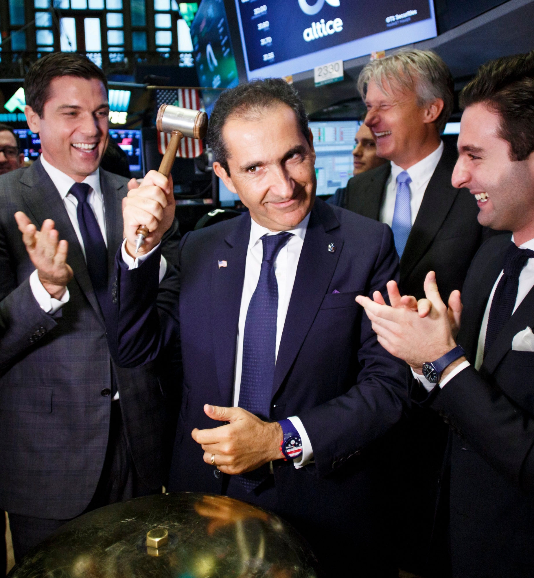 epa06043671 Patrick Drahi (C), the founder of Altice, pretends to hit himself in the head with a mallet after ringing a ceremonial bell during the initial public offering of Altice USA, a cable and telecommunications company, while standing with Thomas W. Farley (L), the President of the NYSE, and other members of the company's leadership on the floor of the New York Stock Exchange in New York, New York, USA, 22 June 2017. The company raised an estimated 1.9 billion dollars with the initial public offering.  EPA/JUSTIN LANE USA NEW YORK ALTICE IPO AT NYSE