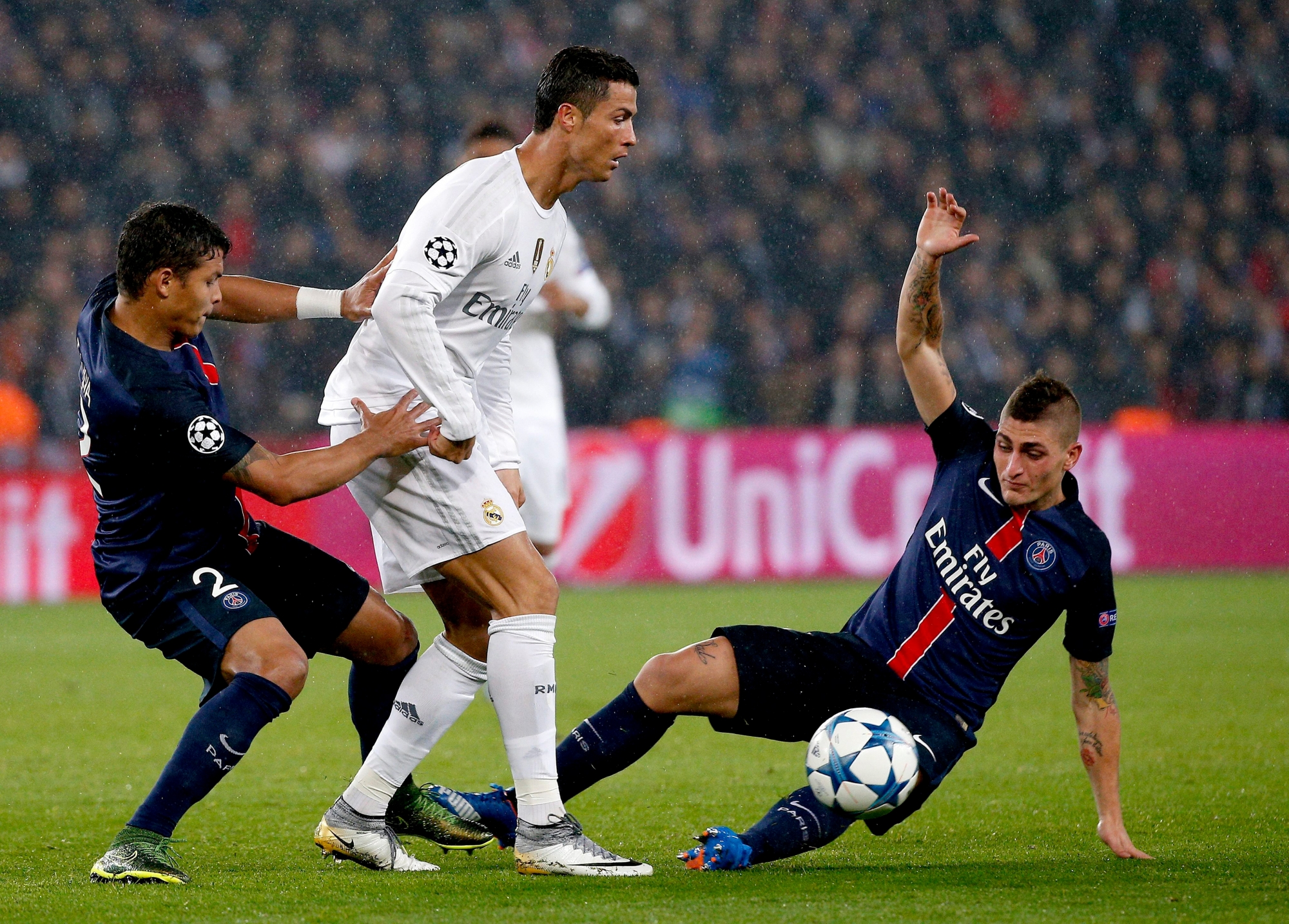 epa04987840 Cristiano Ronaldo of Real Madrid (C) vies for the ball with and Thiago Silva of Paris Saint Germain (L) and Marco Verratti of Paris St Germain (R) during the UEFA Champions League group A soccer match between Paris Saint Germain (PSG) and Real Madrid at the Parc des Princes stadium in Paris, France, 21 October, 2015.  EPA/YOAN VALAT FUSSBALL CL 2015/16 PSG REAL MADRID