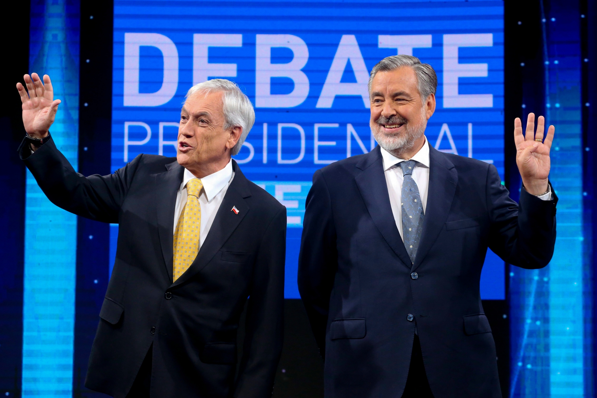 In this Dec. 11, 2017 photo, Chile Vamos candidate and former President Sebastian Pinera, left, and Nueva Mayoria or New Majority ruling party candidate Alejandro Guillier, pose for photos before the start of a live, televised presidential debate, in Santiago, Chile. The presidential run-off election on Dec. 17 is expected to be a tight contest between Pinera and Guillier. (AP Photo/Esteban Felix) Chile Elections
