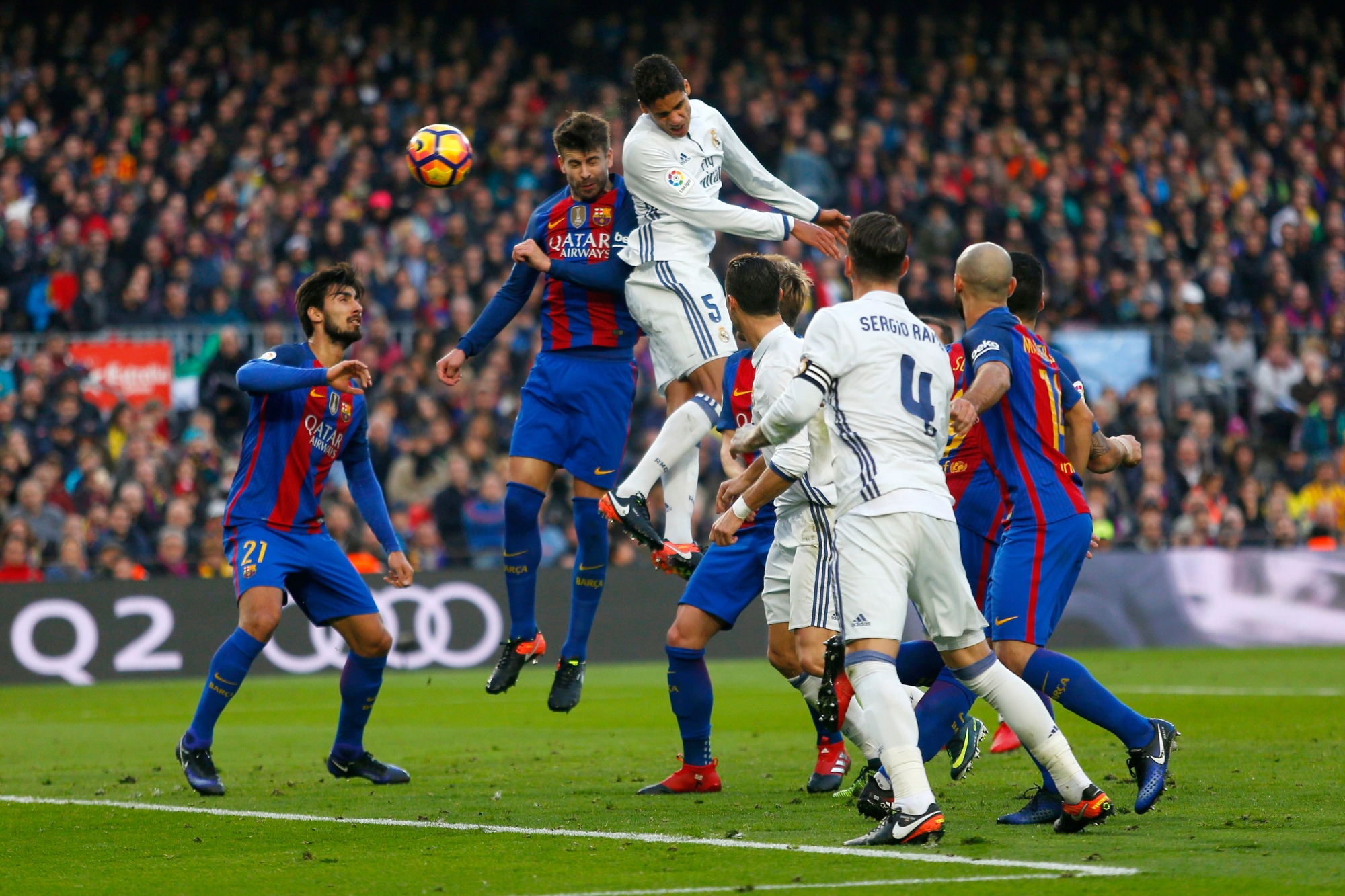 Real Madrid's Varane, top, goes for a header with Barcelona's Gerard Pique, top left, during the Spanish La Liga soccer match between FC Barcelona and Real Madrid at the Camp Nou stadium in Barcelona, Spain, Saturday, Dec. 3, 2016. The match ended in a 1-1 draw. (AP Photo/Francisco Seco) SPANIEN FUSSBALL BARCELONA REAL MADRID