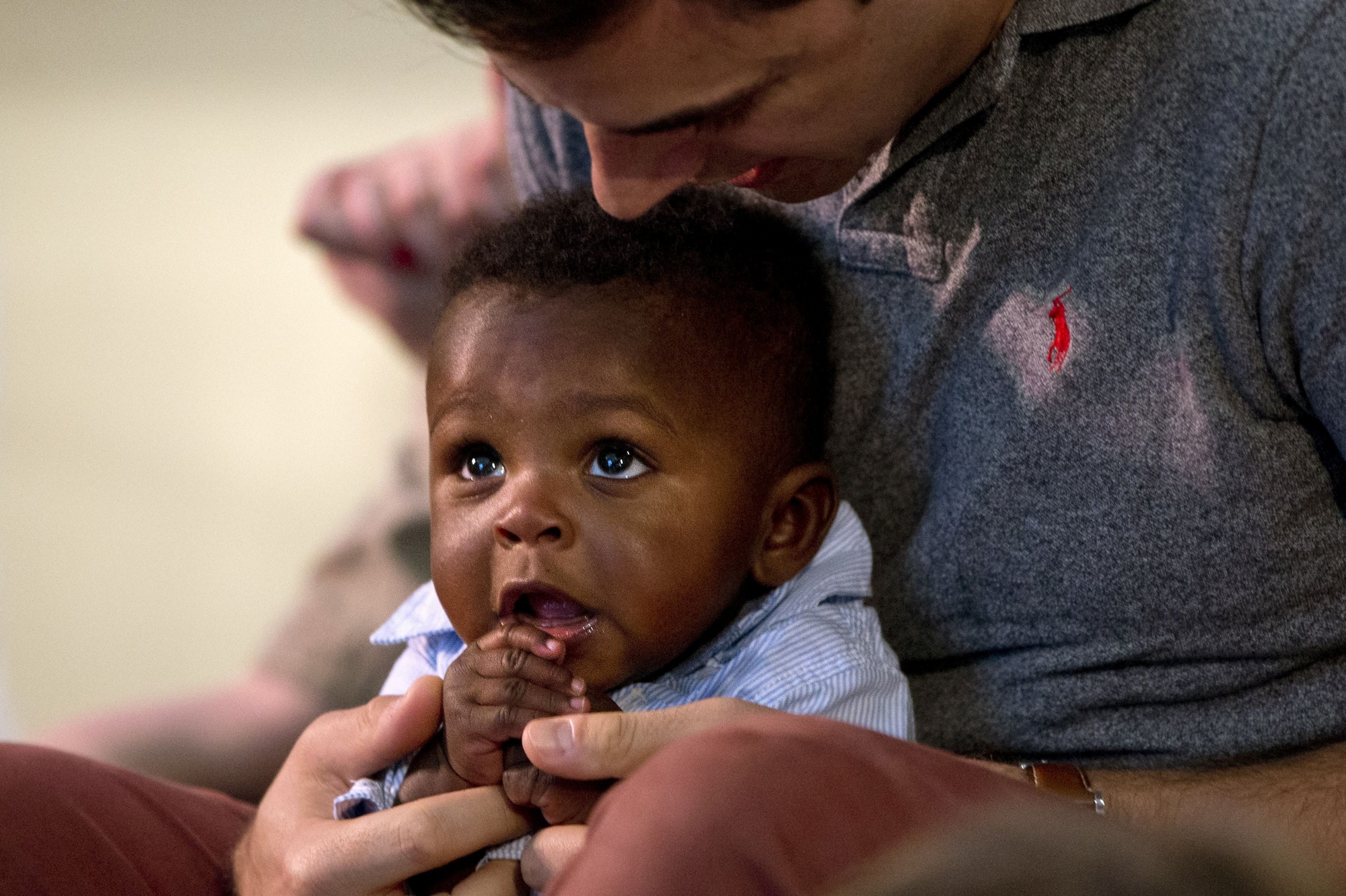 SOCIAL VALUES: Brooks Brunson holds his son's hands in prayer during "children's prayers" as the family attends church at Capitol Hill United Methodist Church in Washington, on Sunday, May 8, 2016. Married in 2013, Brooks Brunson and Gregg Pitts always knew they wanted to have a family together, and were delighted when they were able to start the adoption process for their son shortly after beginning to look for a match in 2015. The child's birth mother had no problem with a same-sex couple adopting the baby. "We're an interracial same-sex couple family," says Brunson, "But our day-to-day life is picking up dry cleaning, getting to work on time, making sure Thomas has his bottle prepared - we're the most boring people I know. But then when I take a step back I realize we are very unique. But I believe this is exactly where God wants me to be." The District of Columbia legalized gay marriage in 2010. (AP Photo/Jacquelyn Martin) USA ALLTAG