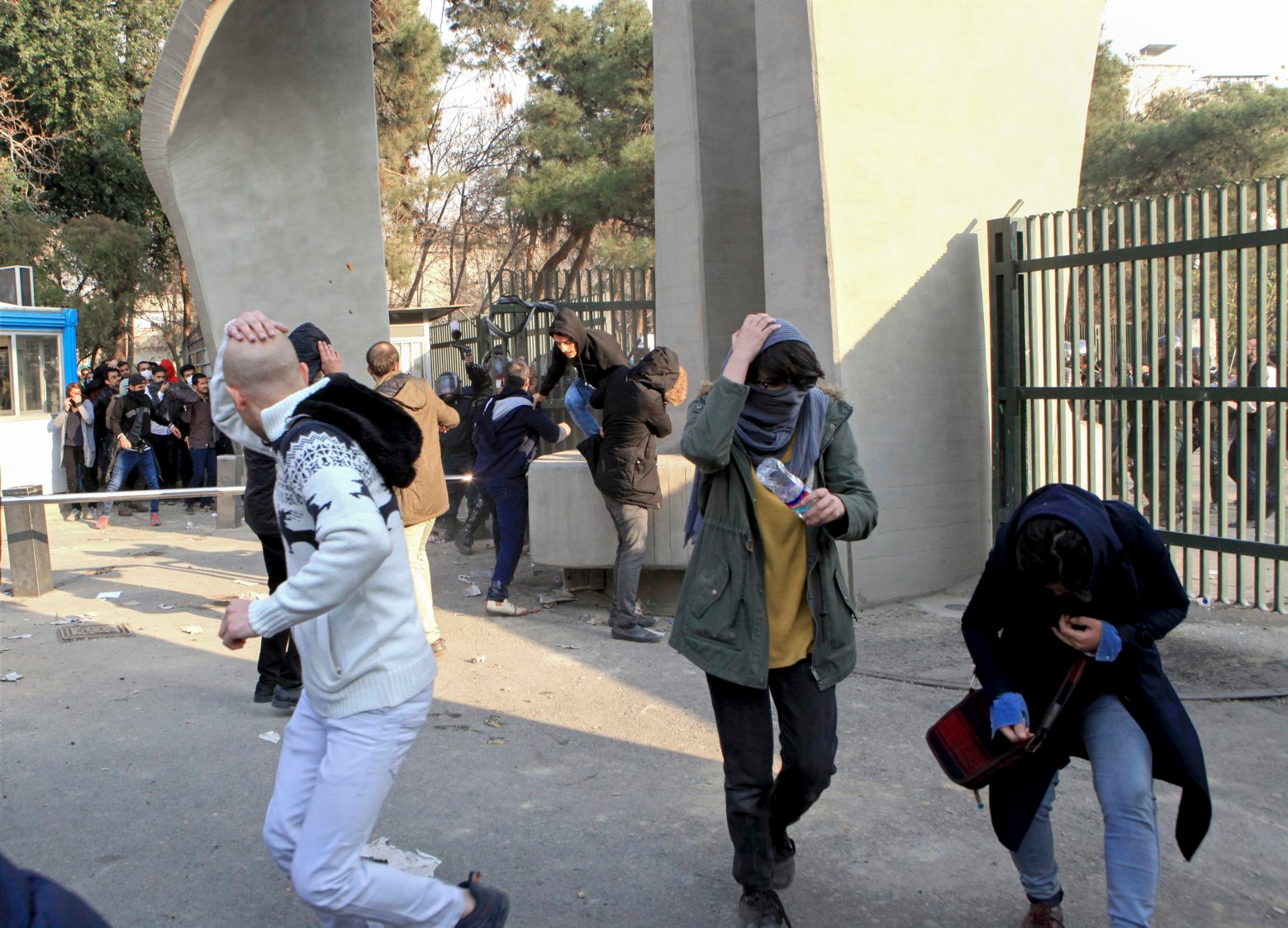 In this photo taken on Saturday, Dec. 30, 2017, by an individual not employed by the Associated Press and obtained by the AP outside Iran, university students run away from stones thrown by police during an anti-government protest inside Tehran University, in Tehran, Iran. Demonstrations, the largest seen in Iran since its disputed 2009 presidential election, have brought six days of unrest across the country and resulted in over 20 deaths. (AP Photo) Iran Protests