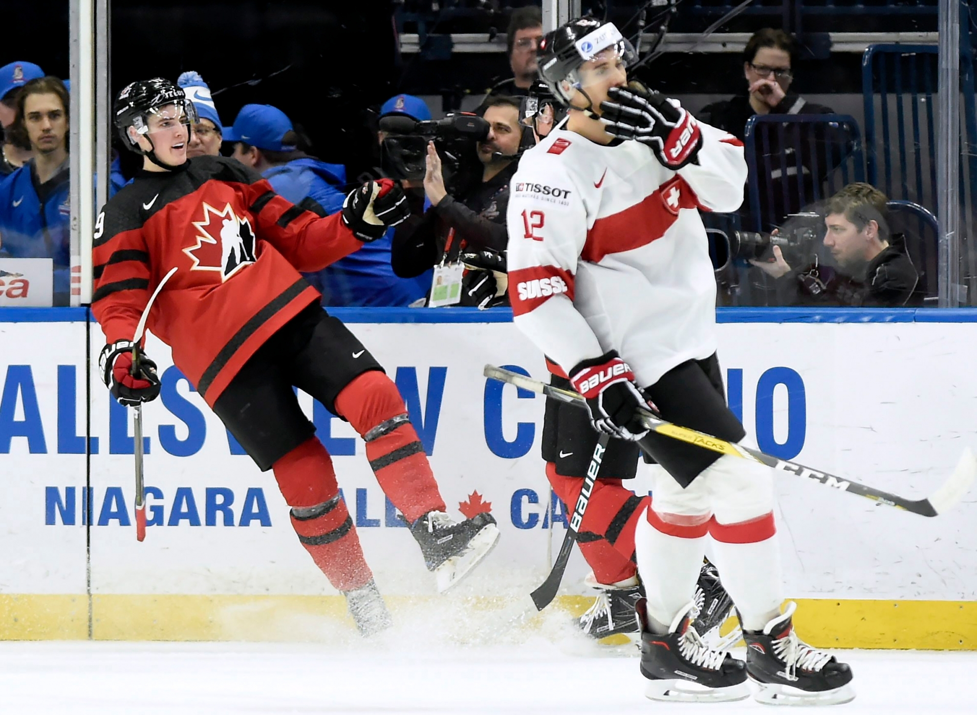 Canada's Drake Batherson (19) celebrates his goal as Switzerland's Tobias Geisser (12) skates past during the second period of a quarterfinal in the IIHF world junior hockey championships in Buffalo, N.Y., Tuesday, Jan. 2, 2018. (Nathan Denette/The Canadian Press via AP) World Juniors Switzerland Canada Hockey