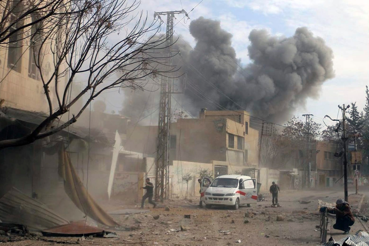 This photo provided by the Syrian Civil Defense White Helmets, which has been authenticated based on its contents and other AP reporting, shows a plume of smoke rises while civil defense workers arrive at the scene of an attack after airstrikes hit a rebel-held suburb near Damascus, Syria, Thursday, Feb. 8, 2018. Syrian rescue workers and activists say the death toll from ongoing government strikes on the opposition-held region near the capital Damascus has risen to at least 35. (Syrian Civil Defense White Helmets via AP) Syria