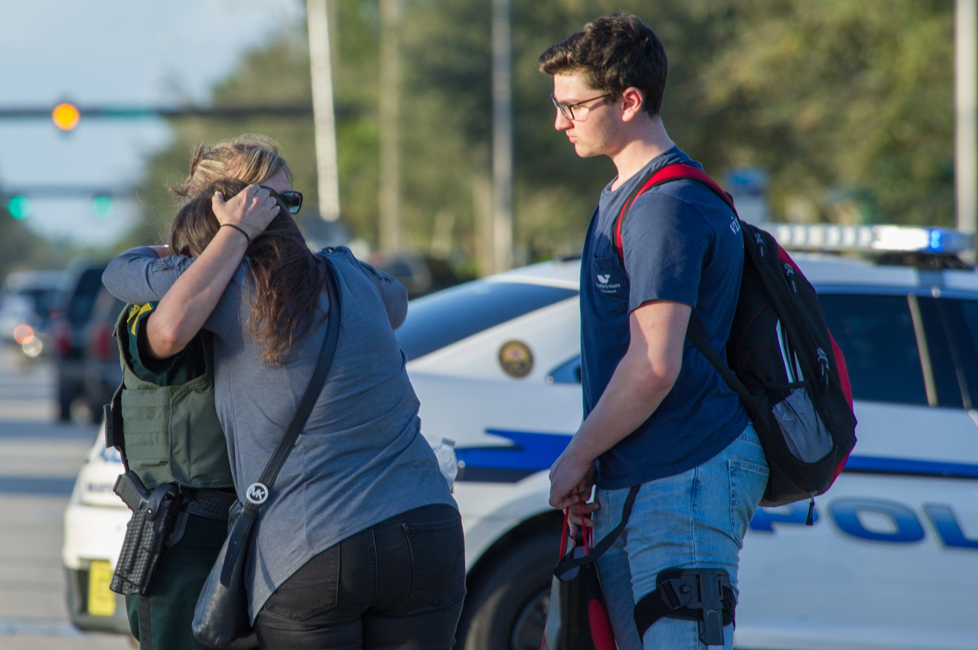 epa06525834 A woman is comforted by a police officer after a shooting at Marjory Stoneman Douglas High School in Parkland, Florida, USA, 14 February 2018. Multiple fatalities have been reported and several more injured at a high school northwest of Miami. According to law enforcement the suspect is in custody. Some media are reporting the suspect as  former student, Nicolas Cruz.  EPA/GIORGIO VIERA USA SCHOOL SHOOTING