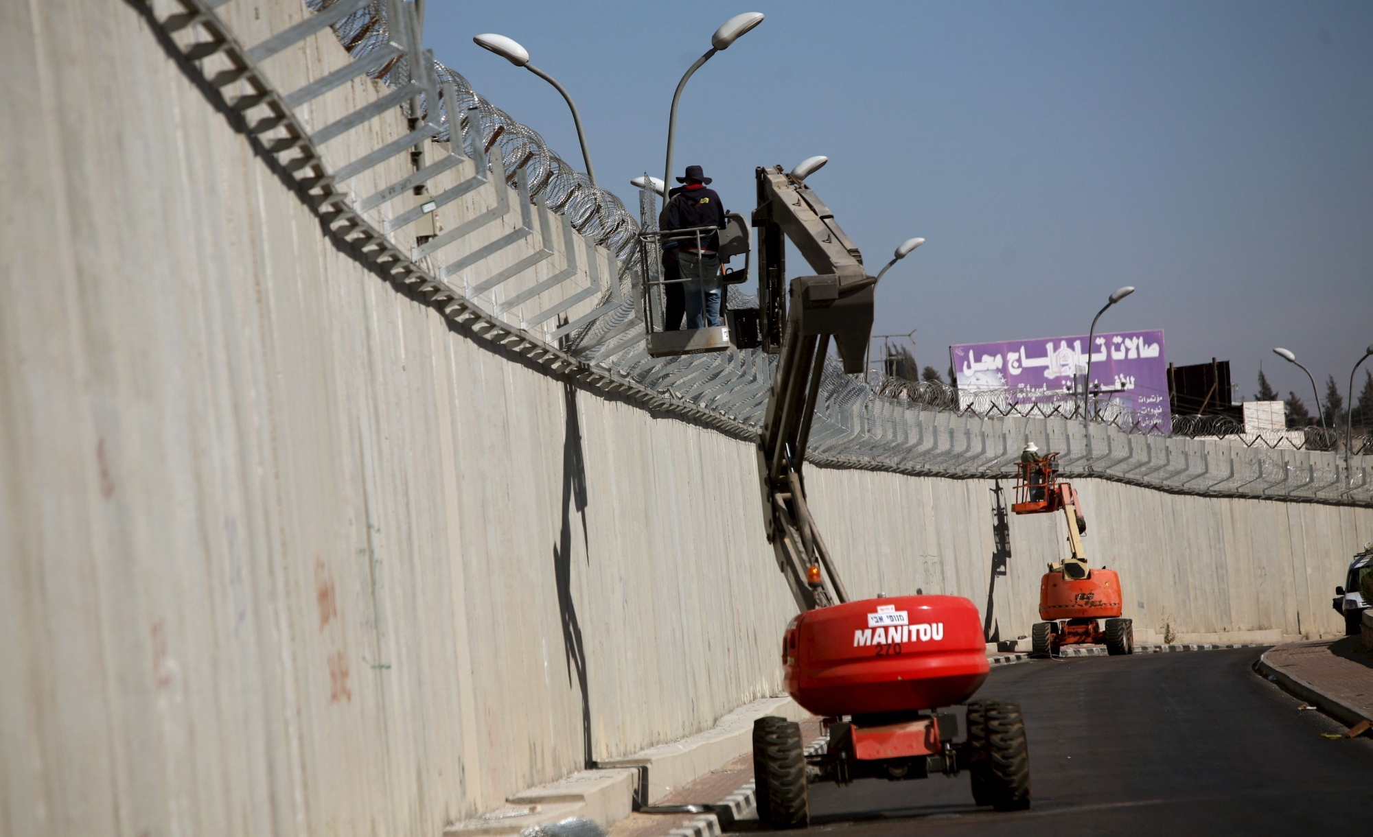 epa01431884 Israeli workers adding Barbed wire to the top of the wall in the West Bank village of A-Ram, 05 August 2008. The Israeli High Court of Justice has recently given the state just 45 days to submit a new route for part of the separation wall that cuts through the Palestinian village of Bil'in, near Ramallah in the central West Bank.
Supreme Court President Dorit Beinisch and Justices Eliezer Rivlin and Ayala Procaccia also laid into the state's representative for ignoring a previous court ruling on the issue just over a year ago after the Bil'in Popular Committee Against the Wall and Settlements took the state to court. Israel started building the separation wall or barrier to separate Israel proper from the West Bank after a wave of suicide bombings, with many of the bombers coming from the Palestinian territory, killed hundreds and injured thousands of Israelis following the beginning of the second Intifada or Palestinian uprising which began in late 2000.




.  EPA/ATEF SA