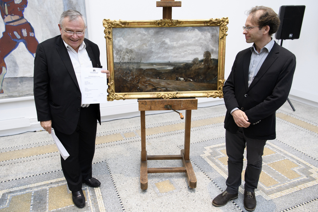 Le conseiller communal Théo Bregnard, à droite, pose avec Alain Monteagle, l'arrière-petit-neveu de John et Anna Jaffe lors de la cérémonie de restitution de "La Vallée de la Stour" ce lundi à La Chaux-de-Fonds.