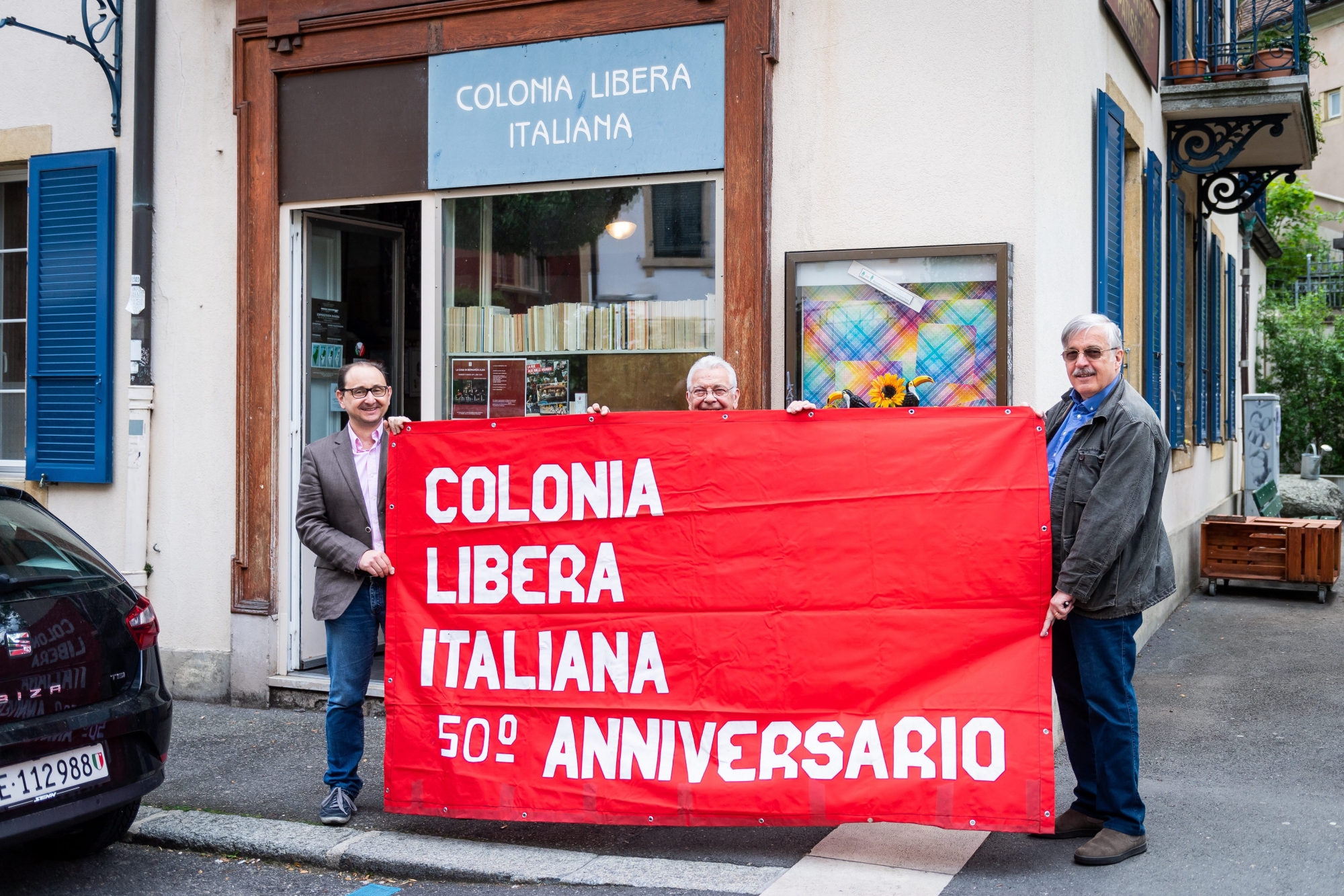 Maurizio Spallacini, Fernando Bruni et Claudio Micheloni tiennent la banderole du 50e anniversaire des Colonies libres italiennes à Neuchâtel.