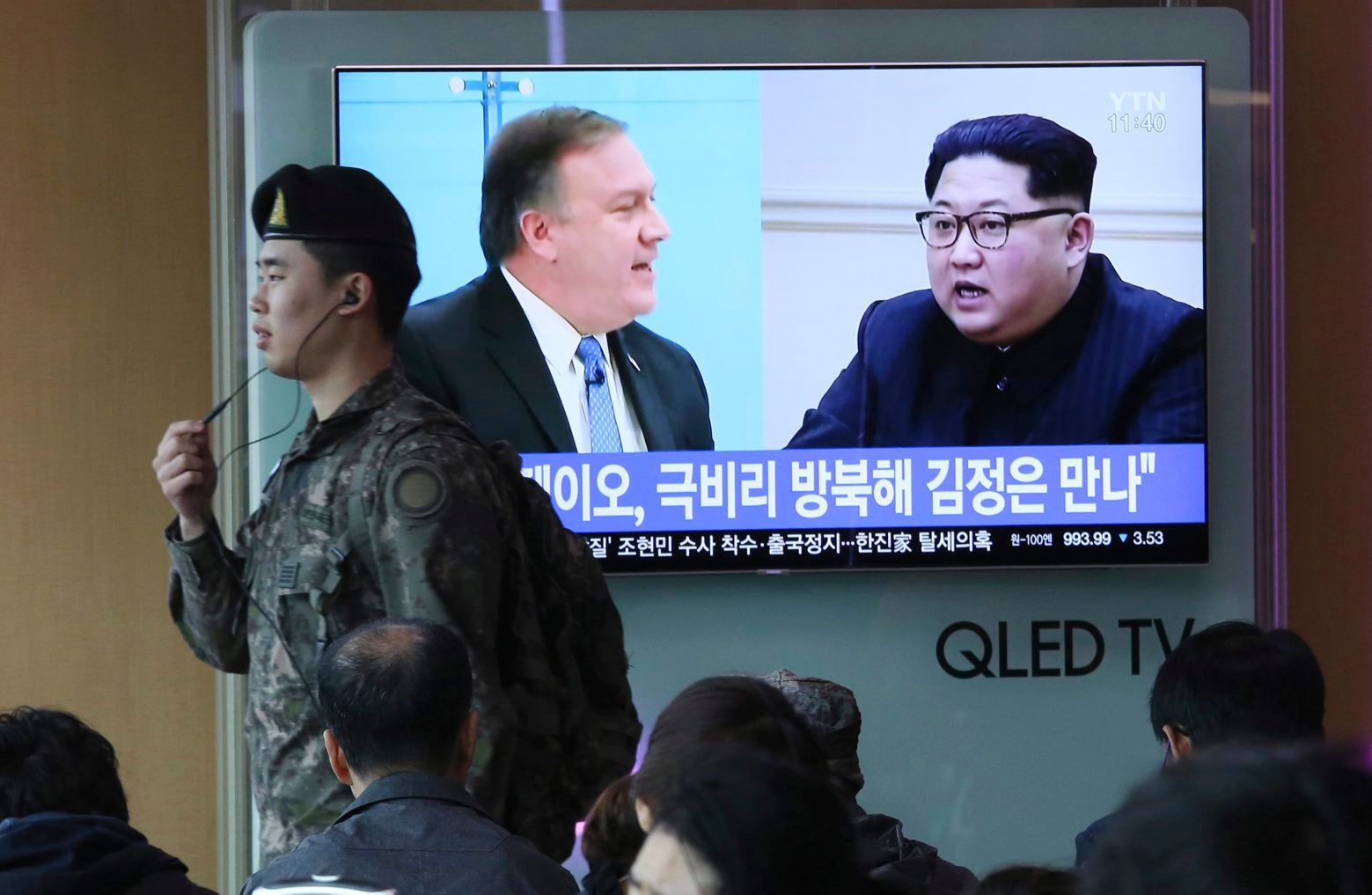 A South Korean army soldier passes by a TV screen showing file footage of CIA Director Mike Pompeo, left, and North Korean leader Kim Jong Un during a news program at the Seoul Railway Station in Seoul, South Korea, Wednesday, April 18, 2018. Pompeo recently traveled to North Korea to meet with leader Kim Jong Un, a highly unusual, secret visit undertaken as the enemy nations prepare for a meeting between President Donald Trump and North Korean leader Kim Jong Un. The signs read: " Mike Pompeo meets with Kim Jong Un." (AP Photo/Ahn Young-joon) South Korea United States North Korea