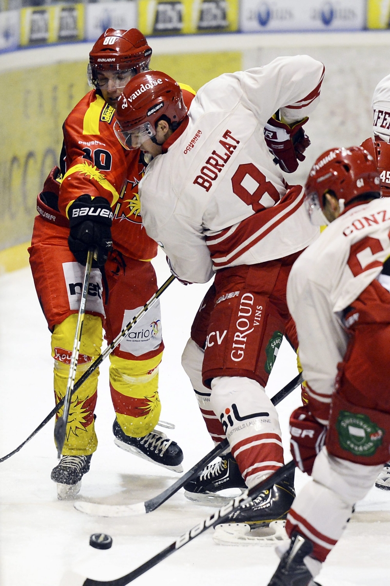 Le joueur sierrois Alian-Th. Pasqualino, gauche, tente d'atteindre le puck contre le joueur lausannois Valentin Borlat, droite, lors du match de National League B, LNB, du championnat suisse de hockey sur glace, entre le HC Sierre-Anniviers et le Lausanne HC, LHC, ce dimanche 25 novembre 2012 a la patinoire de Graben a Sierre. (KEYSTONE/Olivier Maire)