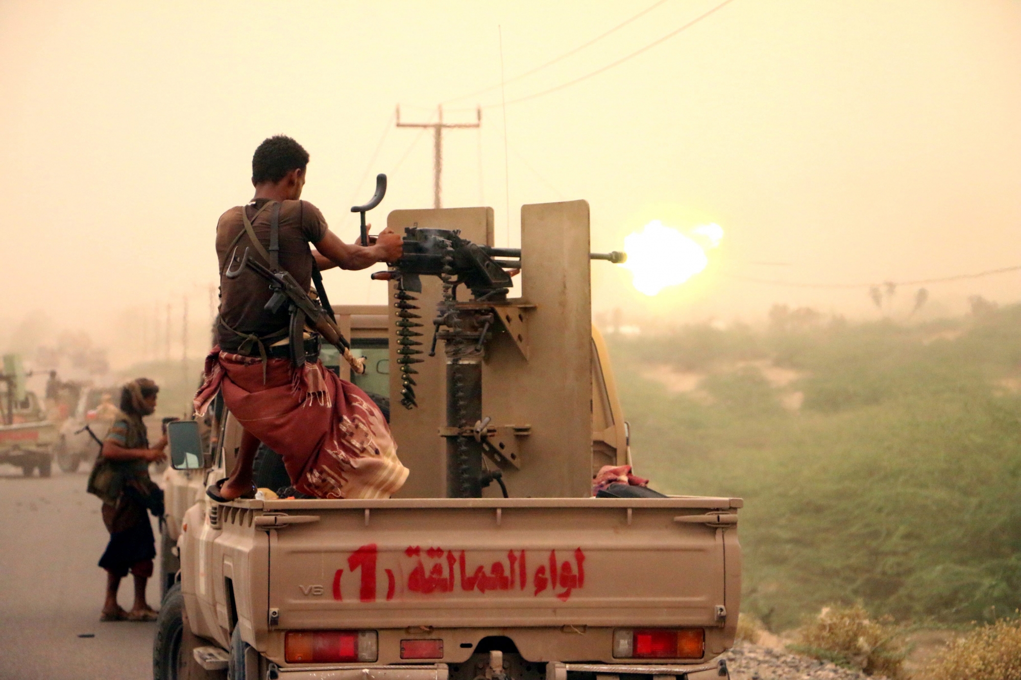 epa06808617 A member of Yemeni government forces fires a heavy machine gun during an offensive against Houthi positions on the outskirts of the western port city of Hodeidah, Yemen, 14 June 2018. According to reports, Yemeni government forces backed by the Saudi-led coalition continued to attack Houthi positions in Hodeidah, in an attempt to gain control of the Houthis-held Red Sea port city, which is the main entry for food into the Arab country.  EPA/NAJEEB ALMAHBOOBI YEMEN CONFLICT HODEIDAH