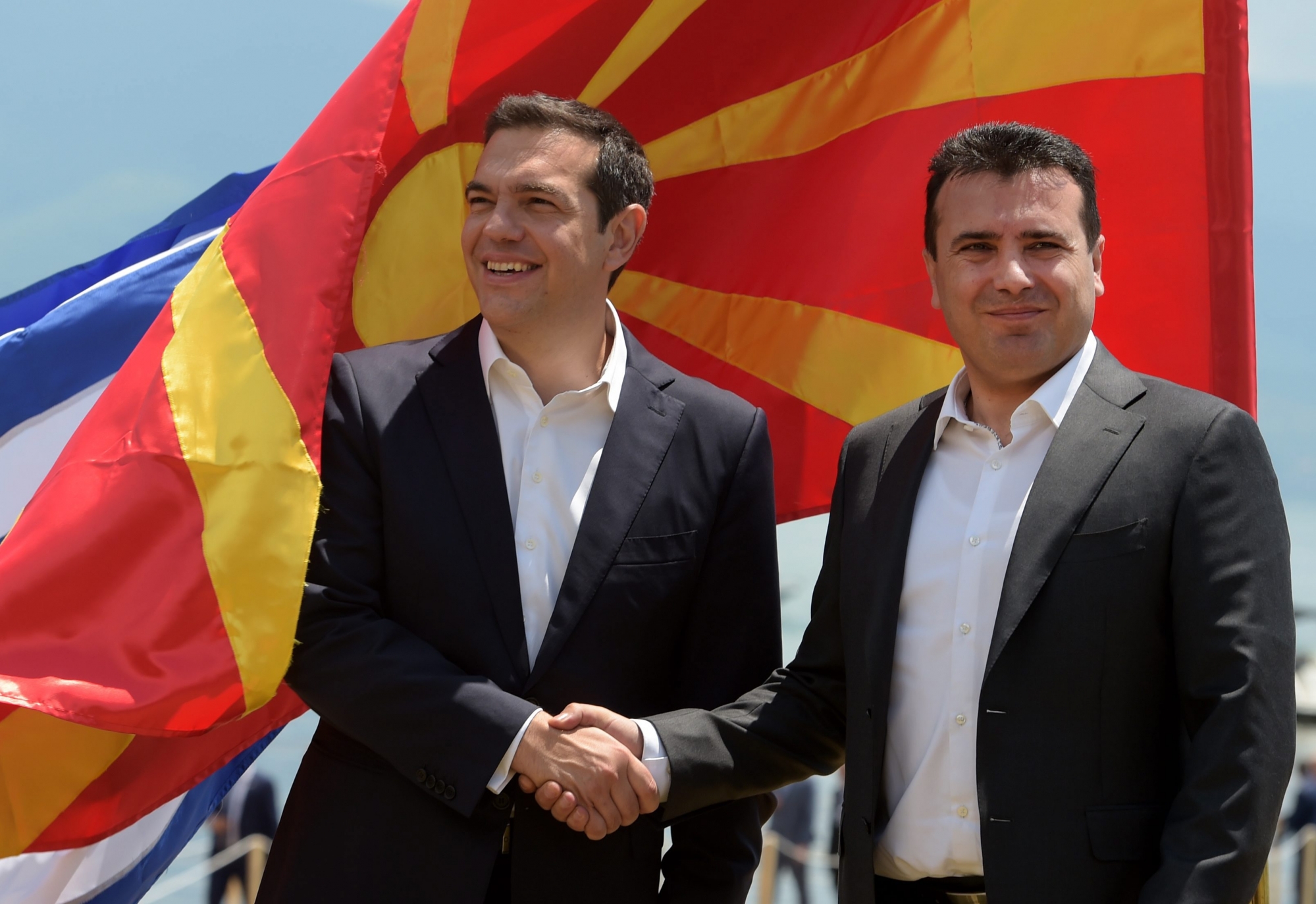 epa06815066 Greek Prime Minister Alexis Tsipras (L) and FYROM Prime Minister Zoran Zaev (R) shake hands after their arrival on Macedonian side of  the Lake Prespa, near Otesevo, the Former Yugoslav Republic of Macedonia (FYROM), 17 June 2018. Prime Ministers from Greece and Macedonia meet in the Prespes lake district, that borders both countries, and sign an agreement aimed at ending a decades-long dispute between their countries. The agreement shall lead to the renaming of Greece's northern neighbour, as well as its EU and NATO entry.  EPA/NAKE BATEV FYROM GREECE NAME DISPUTE AGREEMENT