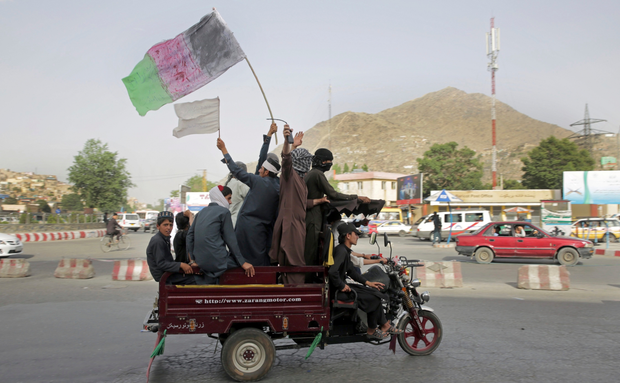 Taliban fighters and their supporters carry a representation of the Afghan national flag and a Taliban flag while riding in a motorized vehicle, in Kabul, Afghanistan, Sunday, June 17, 2018. A suicide bomber struck Sunday in Afghanistan's eastern city of Jalalabad, killing at least 18 people in the second attack in as many days targeting Taliban fighters, security forces and civilians celebrating a holiday cease-fire. (AP Photo/Massoud Hossaini) Afghanistan