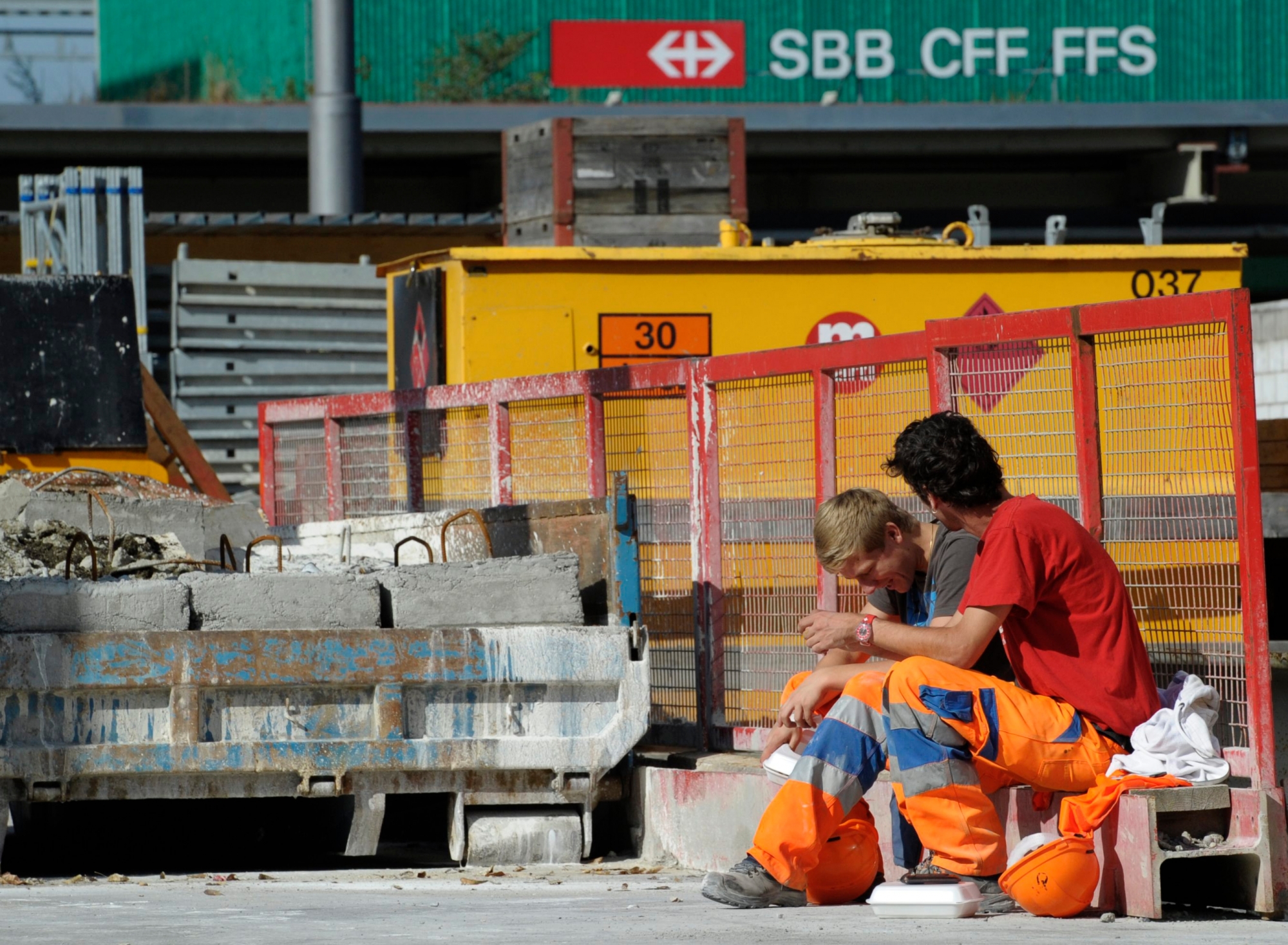 Bauarbeiter sitzen ausserhalb der Baustelle der Durchmesserlinie beim Zuercher Hauptbahnhof, am Dienstag, 18. Oktober 2011, in Zuerich. Die Bauarbeiter streiken, nachdem Faekalien aus den WC's der Zuege oberhalb der Baustelle auf die Bauarbeiter gefallen sind. Vertreter der Gewerkschaft UNIA erachten die von der SBB ergriffenen Massnahmen als ungenuegend. (KEYSTONE/Steffen Schmidt) SCHWEIZ UNIA DURCHMESSERLINIE