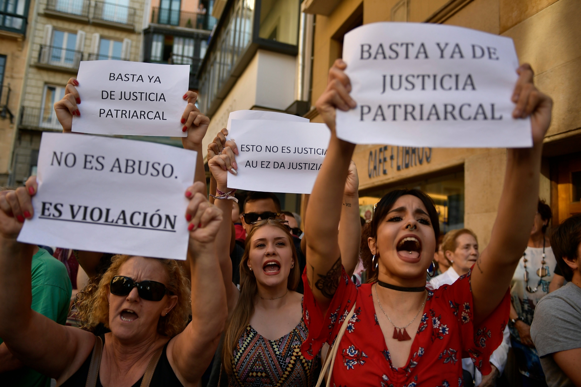 People hold up signs reading, ''It is not an abuse. It's rape'', left, and ''Enough of patriarchal justice'' while protesting against sexual abuse sentence, in Pamplona, northern Spain, Thursday, June 21, 2018. A Spanish court triggered a new wave of outrage Thursday by granting bail to five men acquitted of gang rape and convicted instead on a lesser felony of sexual abuse. It was not clear when the men might leave prison.(AP Photo/Alvaro Barrientos) Spain Sexual Abuse Sentence