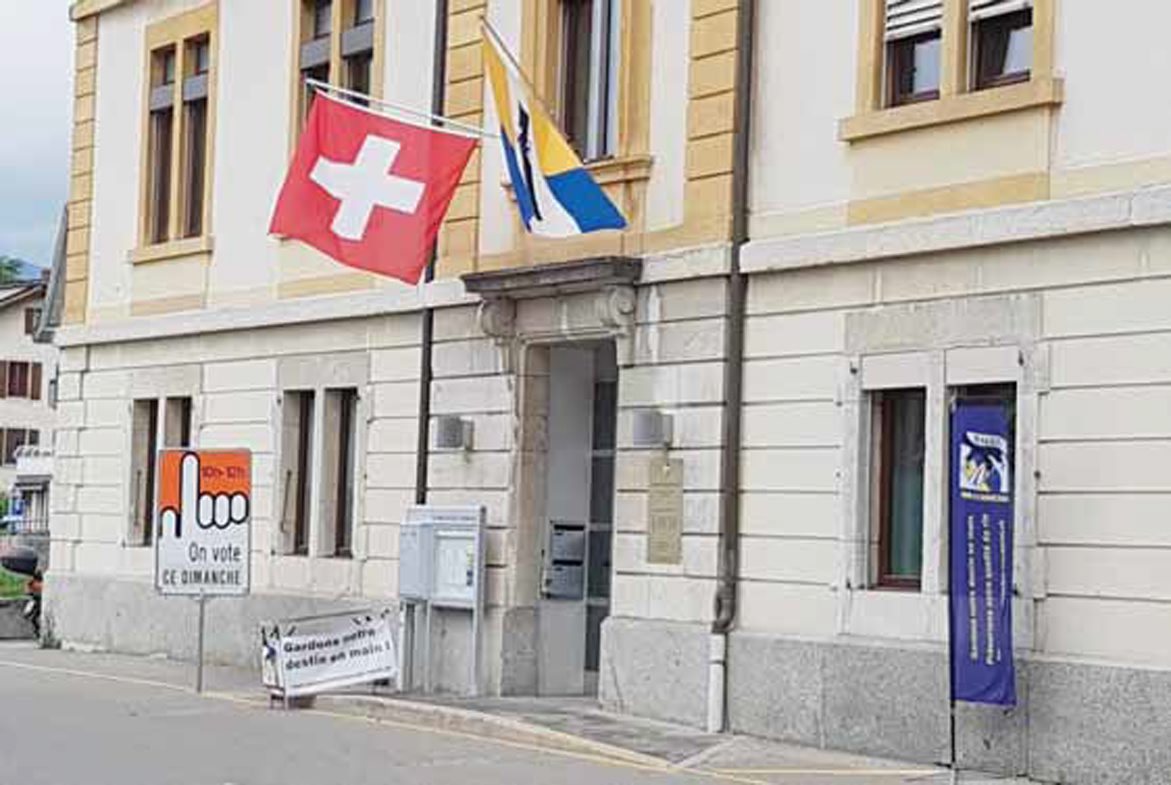 Table et banderoles devant le bureau de vote.