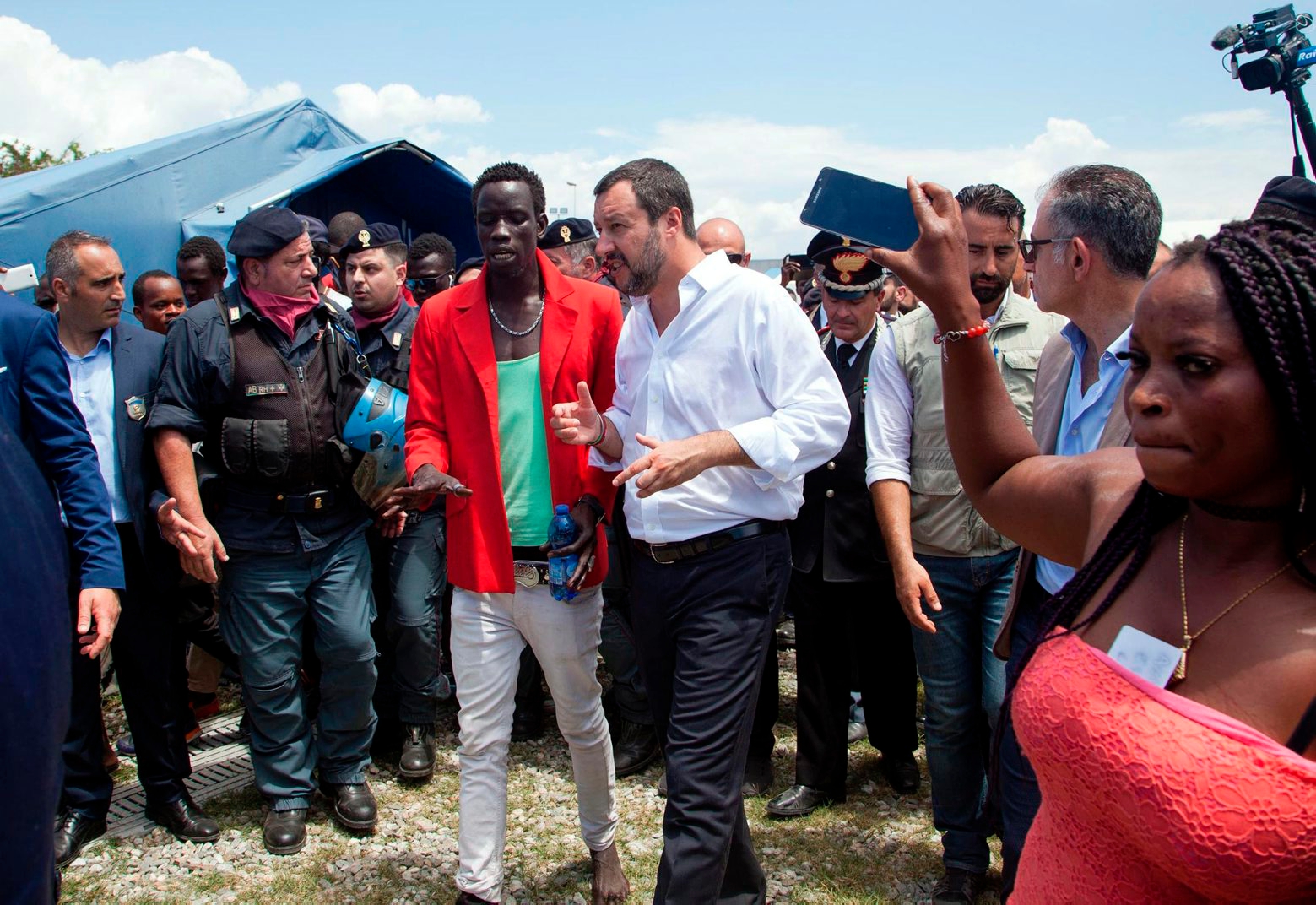 Italian interior minister Matteo Salvini, center, white shirt, pays a visit to the San Ferdinando slum, near Reggio Calabria, Southern Italy, Tuesday, July 10, 2018. Italy's hard-line, anti-migrant interior minister has toured a crime-laden migrant shanty in southern Calabria and vowed to enforce only "limited, controlled and qualified" immigration. Matteo Salvini challenged the "do-gooders" who want to open Italy's ports to migrants to visit the San Ferdinando slum in Reggio Calabria, where he heard of shameless farmers exploiting migrant workers and women being forced into prostitution to get by. Last month, a migrant was killed in San Ferdinando by his former boss. (Marco Costantino/ANSA via AP) ITALY EUROPE MIGRANTS