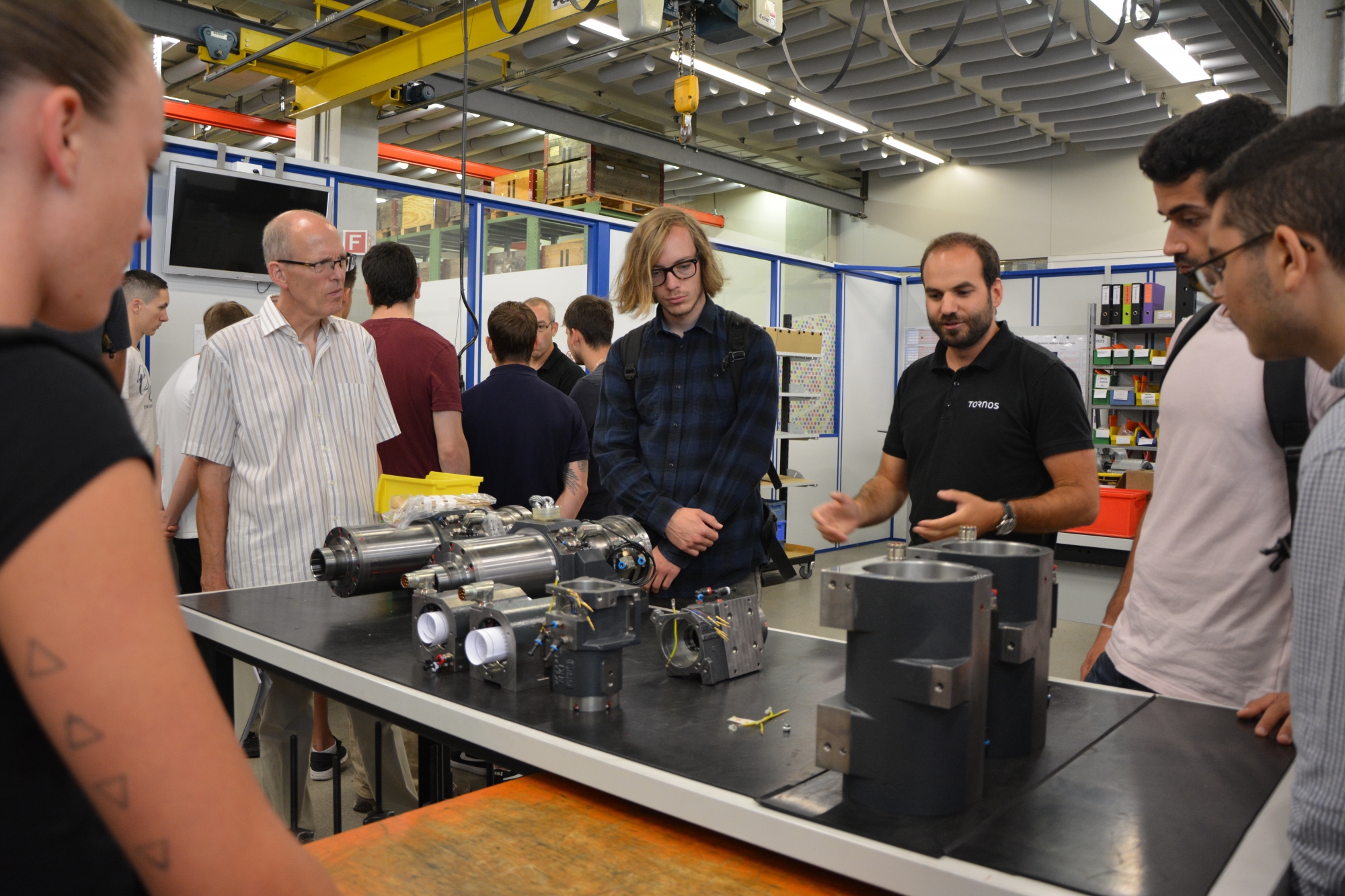 Les étudiants en ingénierie du design industriel lors de la visite des ateliers de Tornos, accompagné par Jean-Claude Ferrier, responsable de la filière à la He-Arc . Août 2018, Moutier.