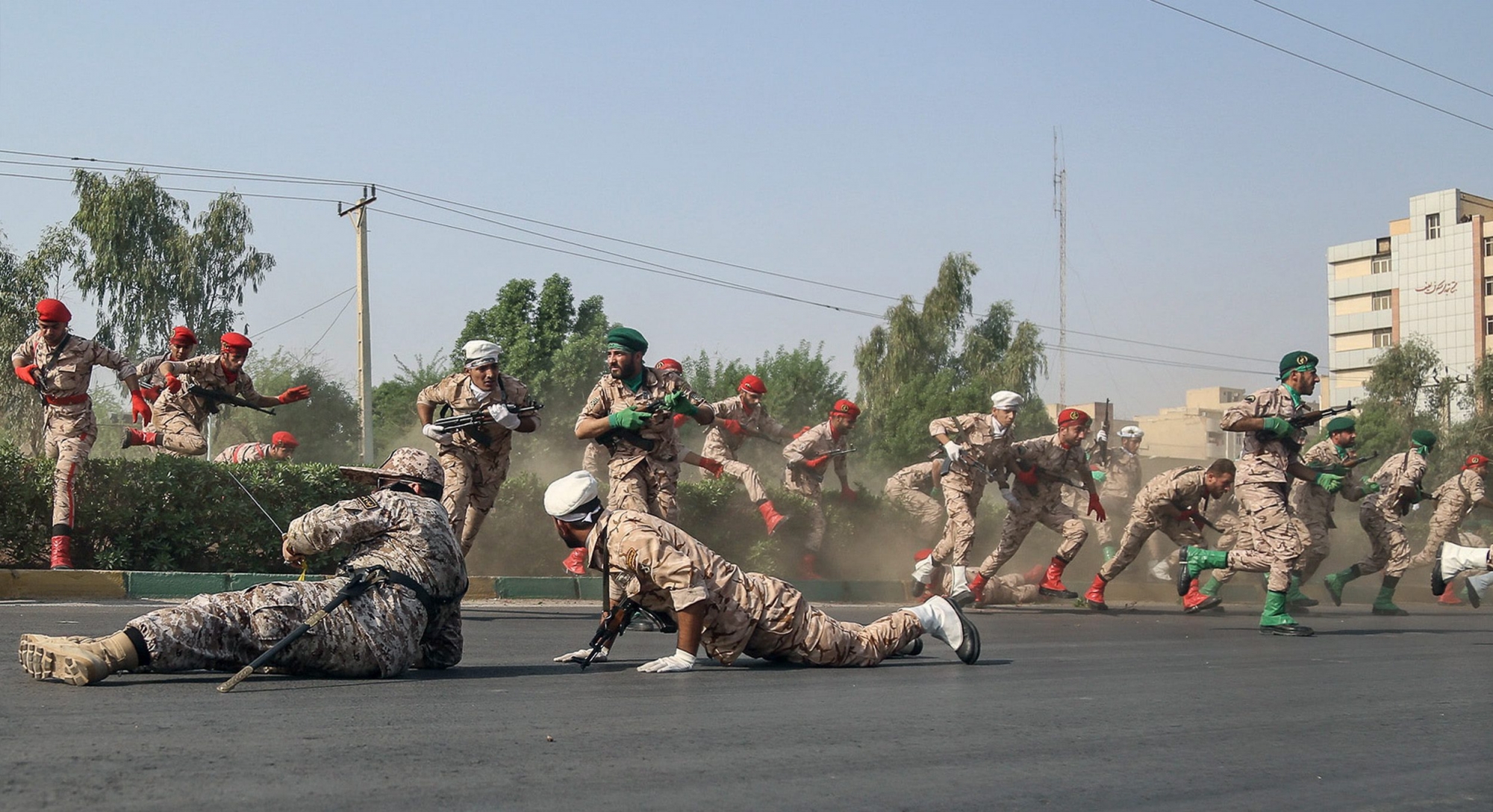 epaselect epa07039277 Iranian soldiers jump over a hedge at a street as they run for cover during a terror attack that occurred during a military parade in the city of Ahvaz, southwest Iran, 22 September 2018. According to media reports, gunmen have opened fire during an Iranian military parade in the south-western city of Ahvaz, killing at least 25 people, including civilians, and injuring dozens.  EPA/MORTEZA JABERIAN epaselect IRAN TERROR ATTACK