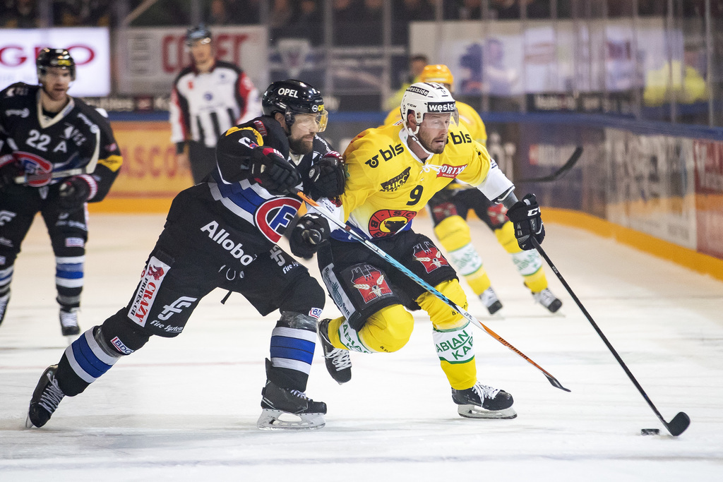 Marc Abplanalp, à gauche, lutte pour le puck avec le joueur bernois Jan Mursak à droite, lors de la rencontre du championnat suisse de hockey sur glace de National League entre le HC Fribourg-Gotteron et le HC Berne. 