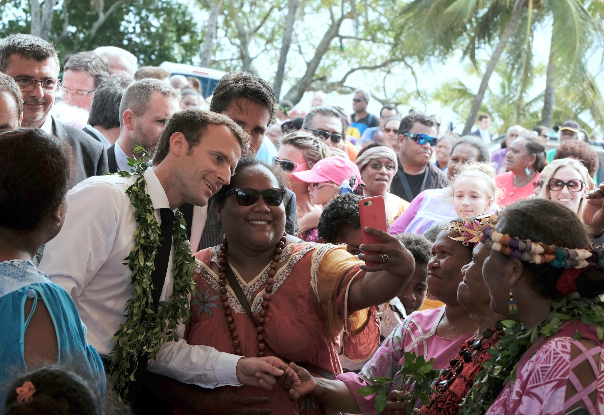 FILE - In this Saturday, May 5, 2018 file photo French President Emmanuel Macron, left, poses for a selfie while meeting residents as part of a remembrance ceremony on the Ouvea Island, off New Caledonia. New Caledonia, a French archipelago in the South Pacific, is preparing for an independence referendum upcoming Sunday Nov. 4, 2018, the last step in a three-decades-long decolonization effort. (AP Photo/Theo Rouby, File) New Caledonia Referendum
