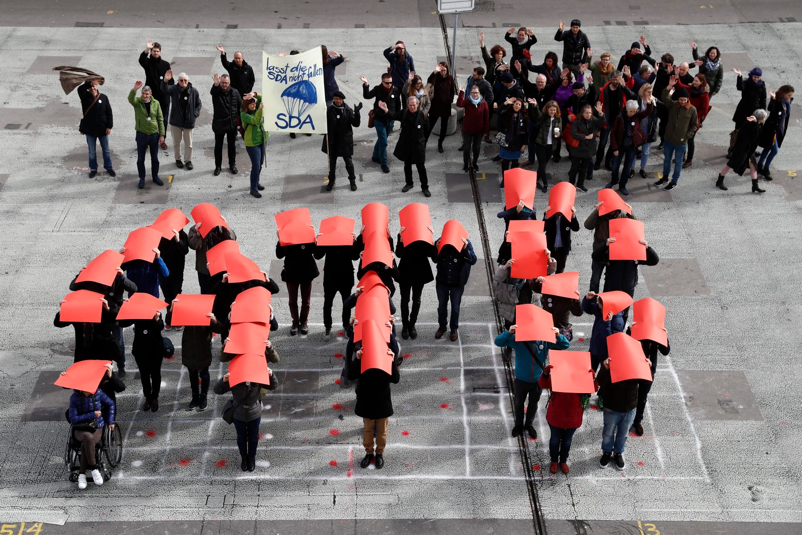 Mitarbeiter der SDA bilden einen sich aufloesenden Schriftzug "ATS" waehrend einer Protestaktion der Belegschaft unter dem Motto "Die sda loest sich auf! Äì Abbau stoppen", am Montag, 12. Maerz 2018, in Bern. (KEYSTONE/Peter Klaunzer) SCHWEIZ SDA PROTEST