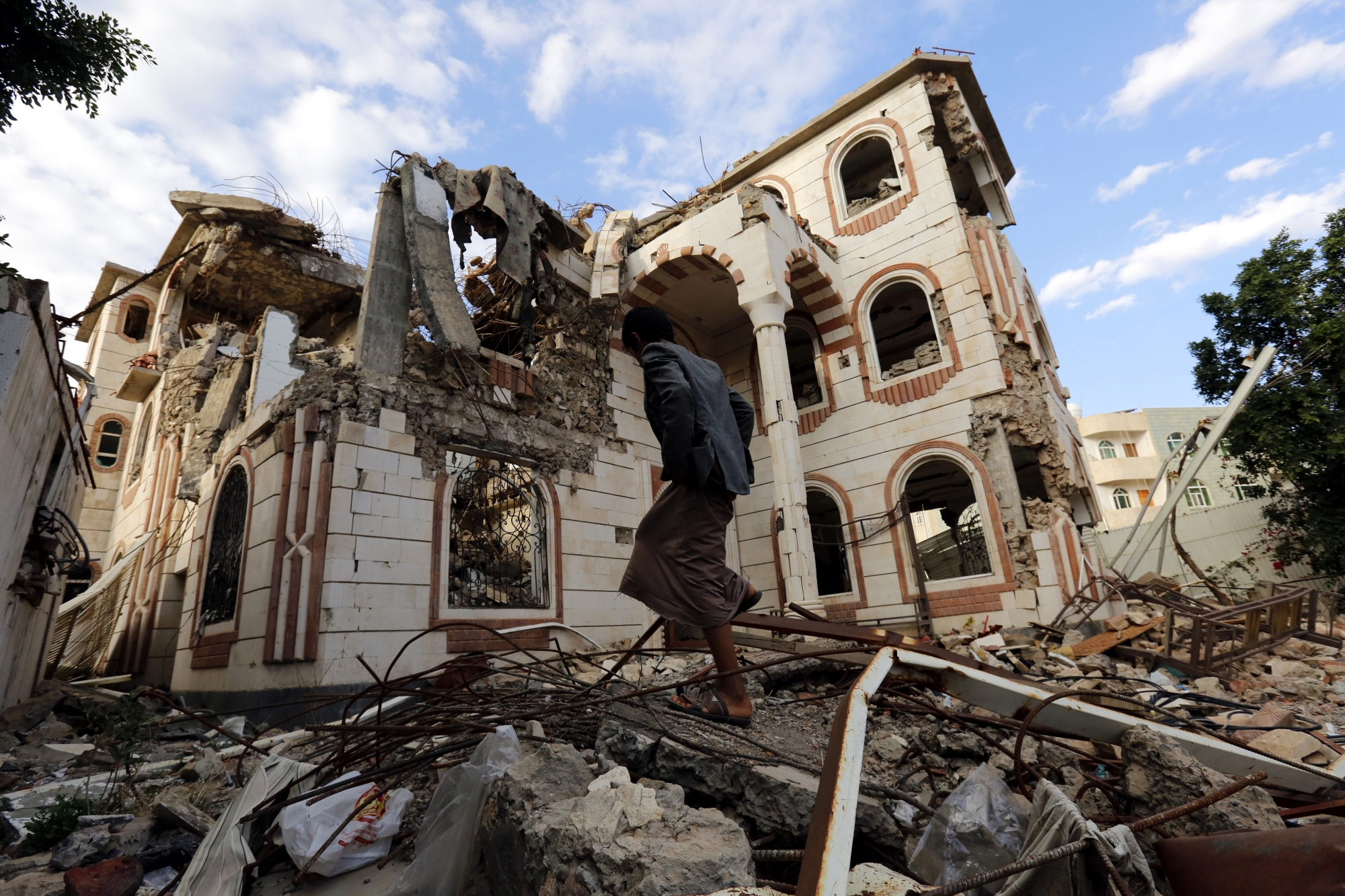 epa07135368 A Yemeni walks amongst debris of a destroyed building allegedly targeted by a previous Saudi-led airstrike, in Sana'a, Yemen, 01 November 2018. According to reports, the US has called for a ceasefire in Yemen and a return to UN-backed peace talks aimed at ending the three-and-half-year conflict between the Saudi-backed Yemeni government and the Houthi rebels.  EPA/YAHYA ARHAB YEMEN CONFLICT PEACE EFFORTS