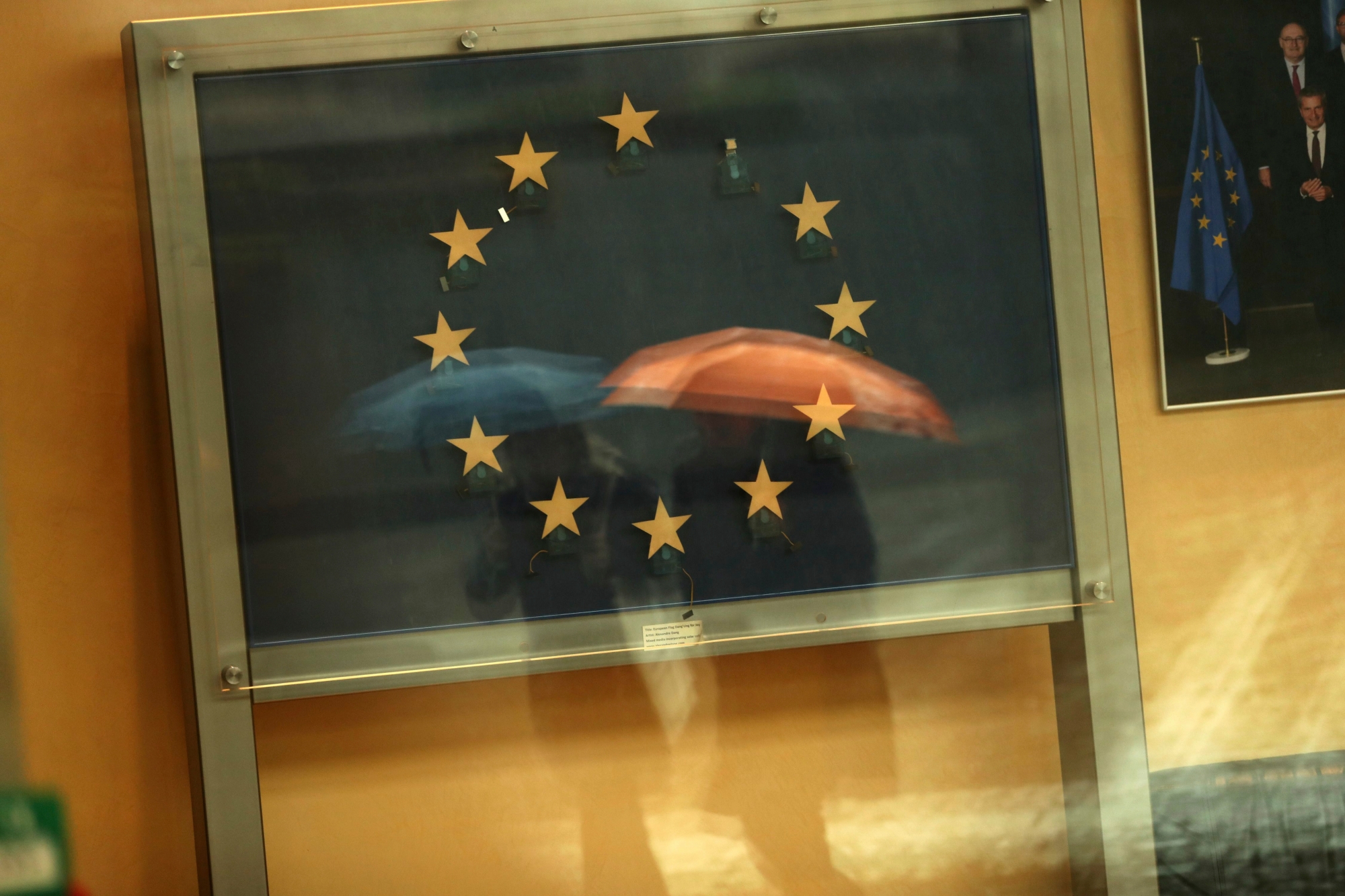 Passers-by are reflected in an artwork based on the European Union flag, with one star missing, in the European Commissions headquarters in Brussels, Monday, Nov. 12, 2018. Britain's European Union partners on Monday ratcheted up political pressure on Prime Minister Theresa May amid signs that some progress is being made in Brexit negotiations. (AP Photo/Francisco Seco) Belgium EU Brexit