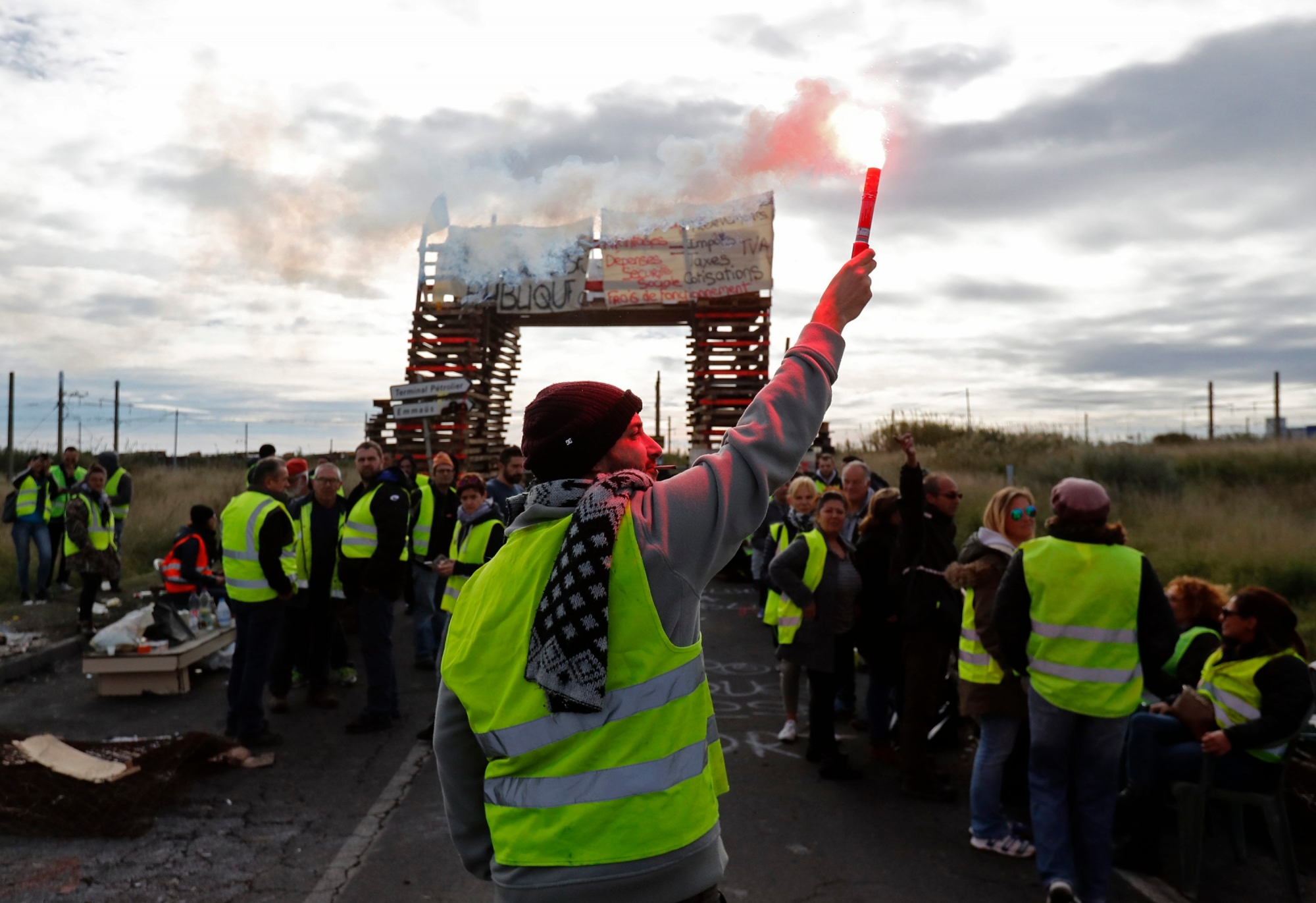 epa07205948 People wearing yellow vests block access to the oil refinery of Frontignan, southern France, 03 December 2018. The so-called gilets jaunes (yellow vests), a protest movement, which reportedly has no political affiliation, is protesting across the nation over high fuel prices.  EPA/GUILLAUME HORCAJUELO FRANCE FUEL TAXES PROTEST