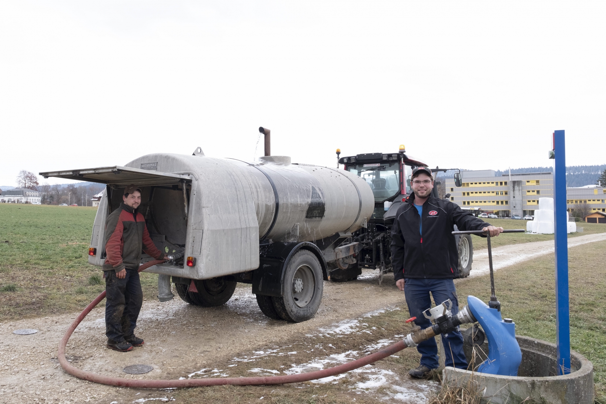 Guillaume Ernst (à gauche) de la ferme des Saneys et Julien Zaug descendu de la sienne à Beauregard pour prendre de l'eau à l'hydrante la plus proche.     