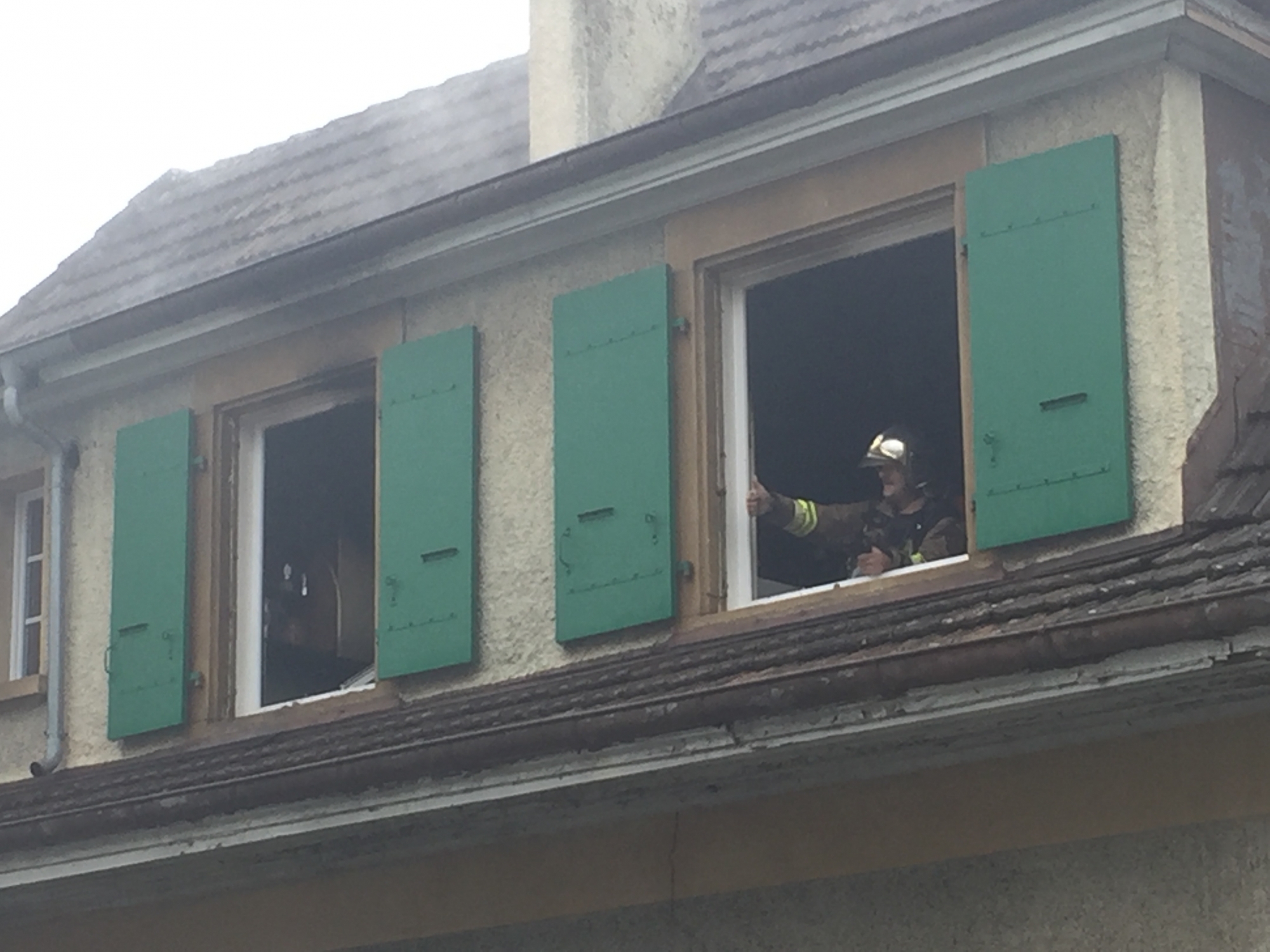 Un pompier à la fenêtre de l'appartement où l'incendie s'est déclaré.